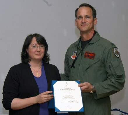 Angellina Ribordy accepts the Volunteer Excellence Award from Col. Jim Jones, 55th Wing Commander, for 18 years of service as a Girl Scout volunteer. Offutt's National Volunteer Week recognition ceremony was held April 19 at the Patriot Club. (U.S. Air Force Photo by Jeff Gates)