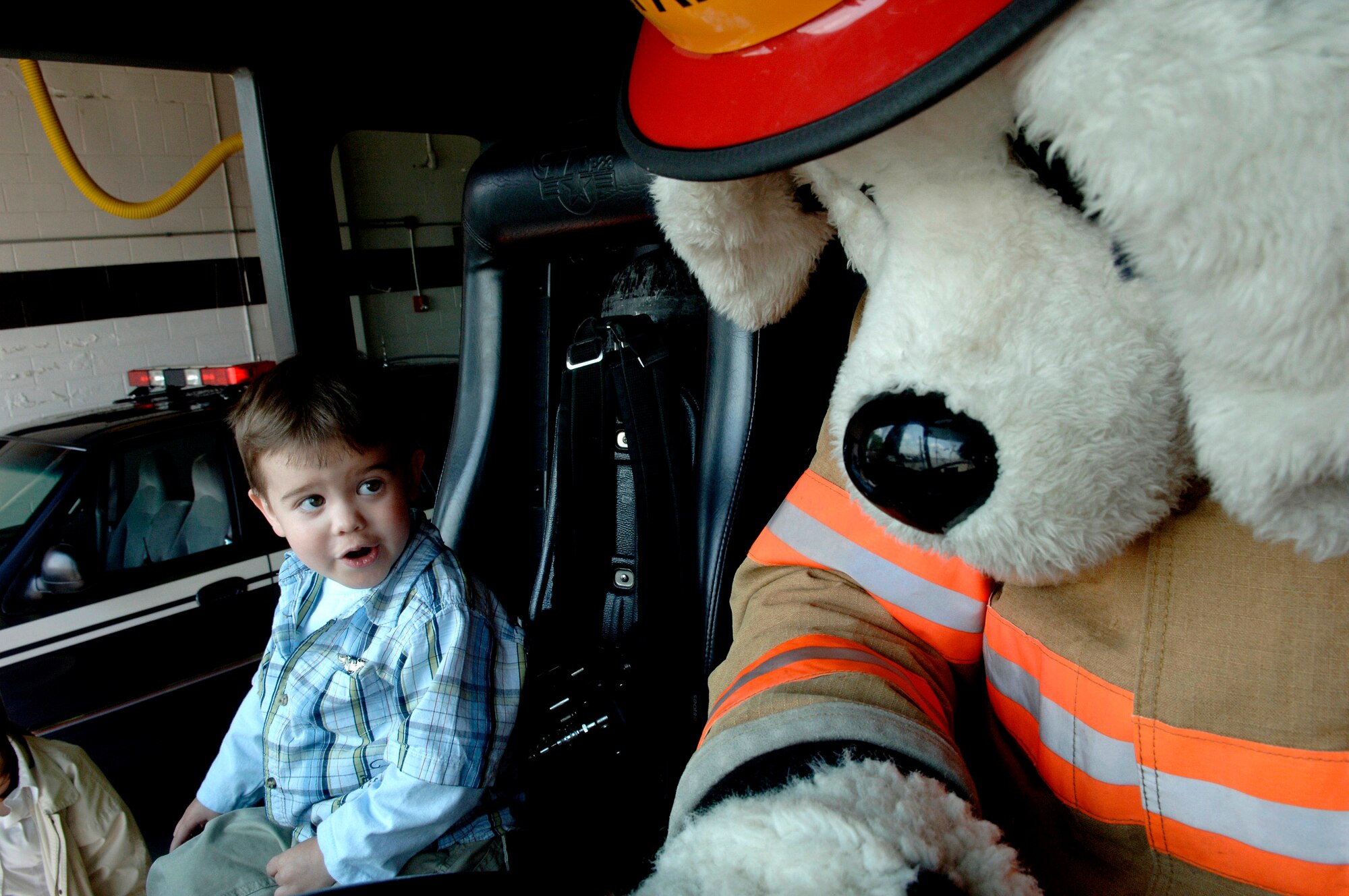 Zachary Moore sits next to Sparky in a firetruck during his April 20 tour of the fire station at Charleston Air Force Base, S.C. Members of the 17th Airlift Squadron chose the 3 year old him for the Pilot for a Day program because he was diagnosed with cancer at 18 months. Zachary is the son of Capt. Christopher Moore, the 437th Airlift Wing chief of Public Affairs. (United States Air Force photo/Airman 1st Class Nicholas Pilch) 
