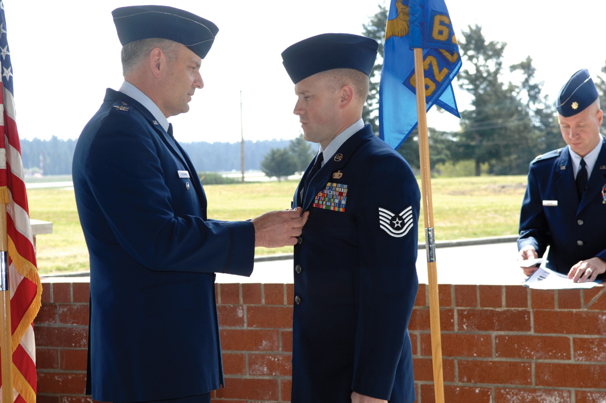 MCCHORD AIR FORCE, Wash. -- Col. Shane Hershman, 62nd Airlift Wing vice commander, pins the Bronze Star Medal on Tech. Sgt. Lawrence Godin, 62nd Operations Support Squadron, on April 20 during a ceremony at Heritage Hill. Sergeant Godin earned the decoration for his bravery and heroism during operations while deployed to Iraq. (U. S Air Force Photo by Abner Guzman)
