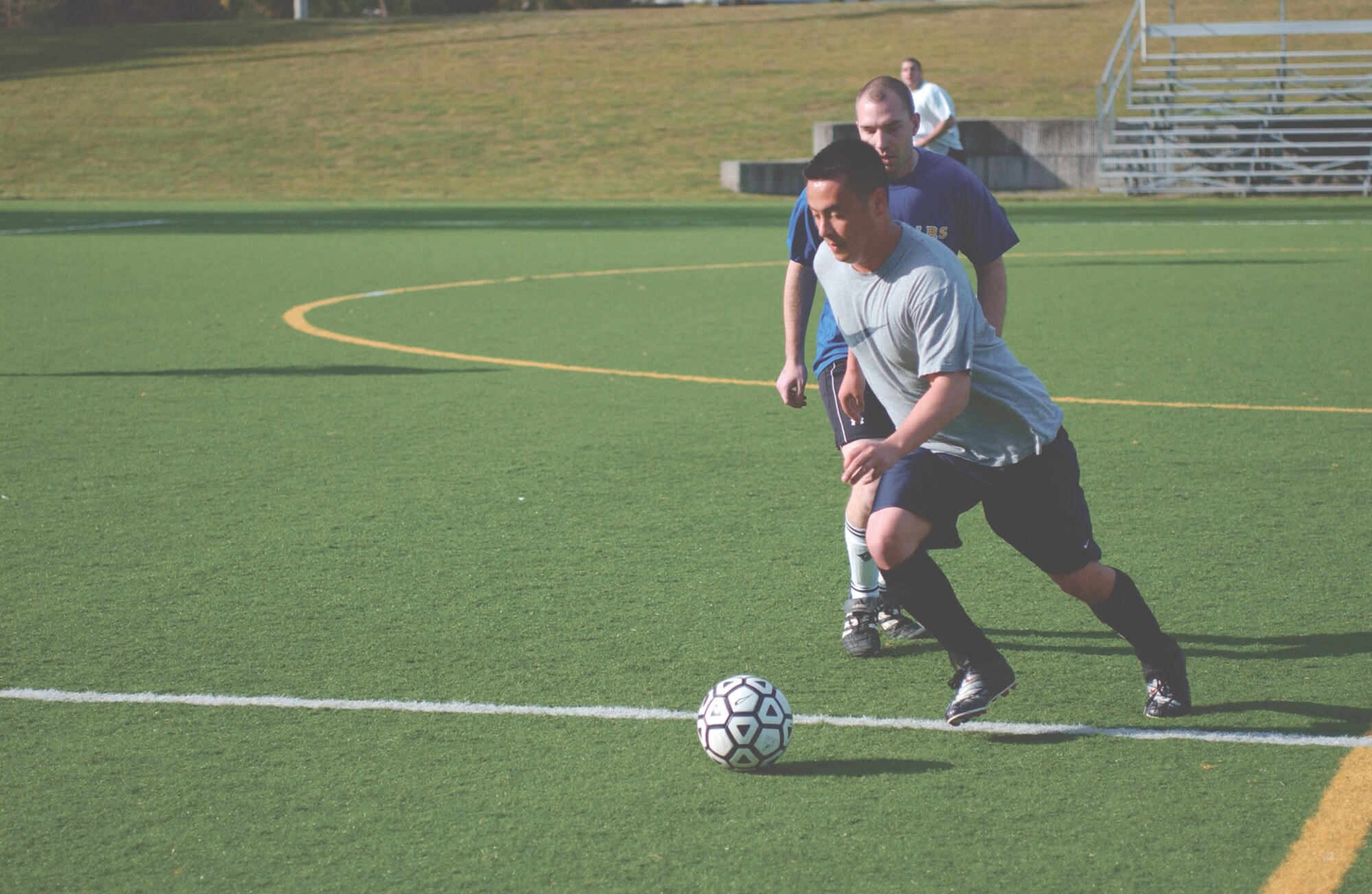 MCCHORD AIR FORCE BASE, Wash. -- Forward Nick Graham, 62nd Medical Group, dribbles past halfback Phillip Spreeman, 62nd Logistics Readiness Squadron, during Monday's intramural soccer game at Rainier Field. LRS notched a 5-1 victory behind a hat trick from forward Xaviour Campbell. (U.S. Air Force Photo by Tyler Hemstreet)