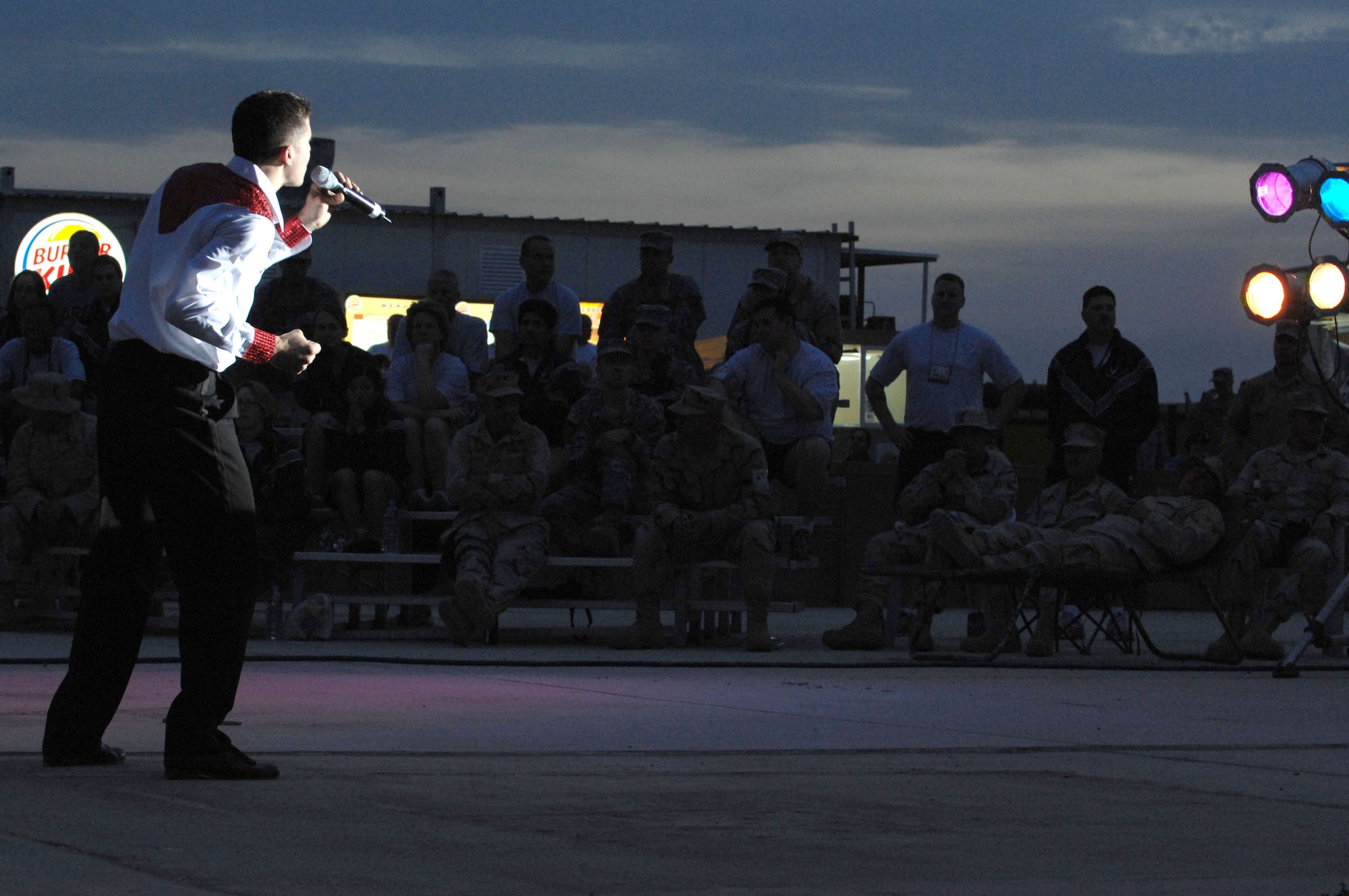 A Tops in Blue Airmen sings to Airmen and Soldiers April 26 at Kirkuk Air Base, Iraq. The 30-member group's goal is to enhance mission productivity for Air Force members around the world. Tops in Blue showcases music, dance and comedy -- all performed by active-duty Airmen who perform 90 minutes of non-stop live entertainment. (U.S. Air Force photo/Senior Airman Bradley A. Lail) 
