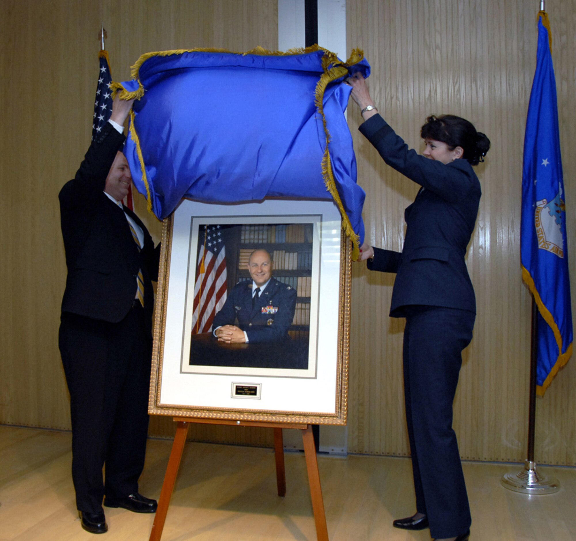 Retired Air Force Col. Jeffrey Sventek and Biomedical Sciences Corps Chief Brig. Gen. Theresa Casey unveil a portrait of Colonel Sventek.  The portrait is the latest in a large collection of former BSC chiefs portraits that adorn the hallway walls of Bldg. 1900. (U.S. Air Force photo/Sandy Wassenmiller)