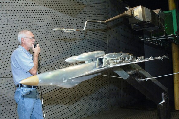 Carey Wofford, Aerospace Testing Alliance outside machinist, speaks to test personnel in the center’s 16-foot-transonic wind tunnel control room who operate the Captive Trajectory Support (CTS) mechanism holding a HARM missile model above the inverted F/A-18E/F Super Hornet model during a store configuration change.