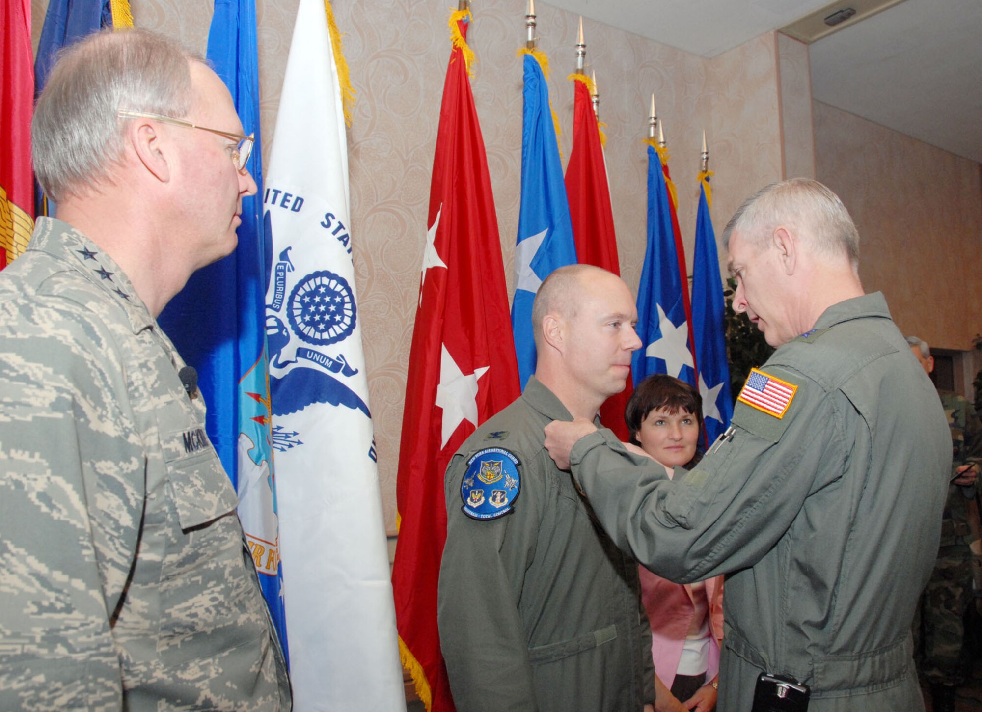 Major Gen. Robert Knauff, chief of staff of the New York Air National Guard, pins the Bronze Star Medal onto Col. John Bartholf, Northeast Air Defense Sector Title 32 commander, while Lt. Gen. Craig McKinley, Air National Guard director, and Lynette Bartholf, Colonel Bartholf's wife, watch April 21.