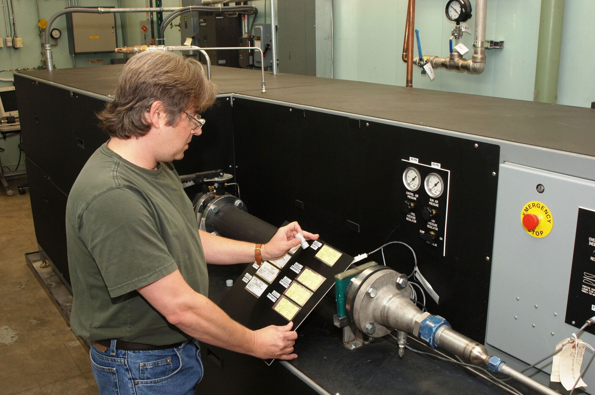 Troy Holland, an ATA instrument technician at AEDC’s Precision Measurement Evaluation Laboratory, applies an Air Force Metrology and Calibration K-stamp of compliance on the repaired flow bench.