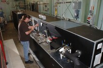 Brian Hale, an ATA instrument technician at AEDC’s Precision Measurement Evaluation Laboratory, installs a flow meter onto the flow bench for calibrating.