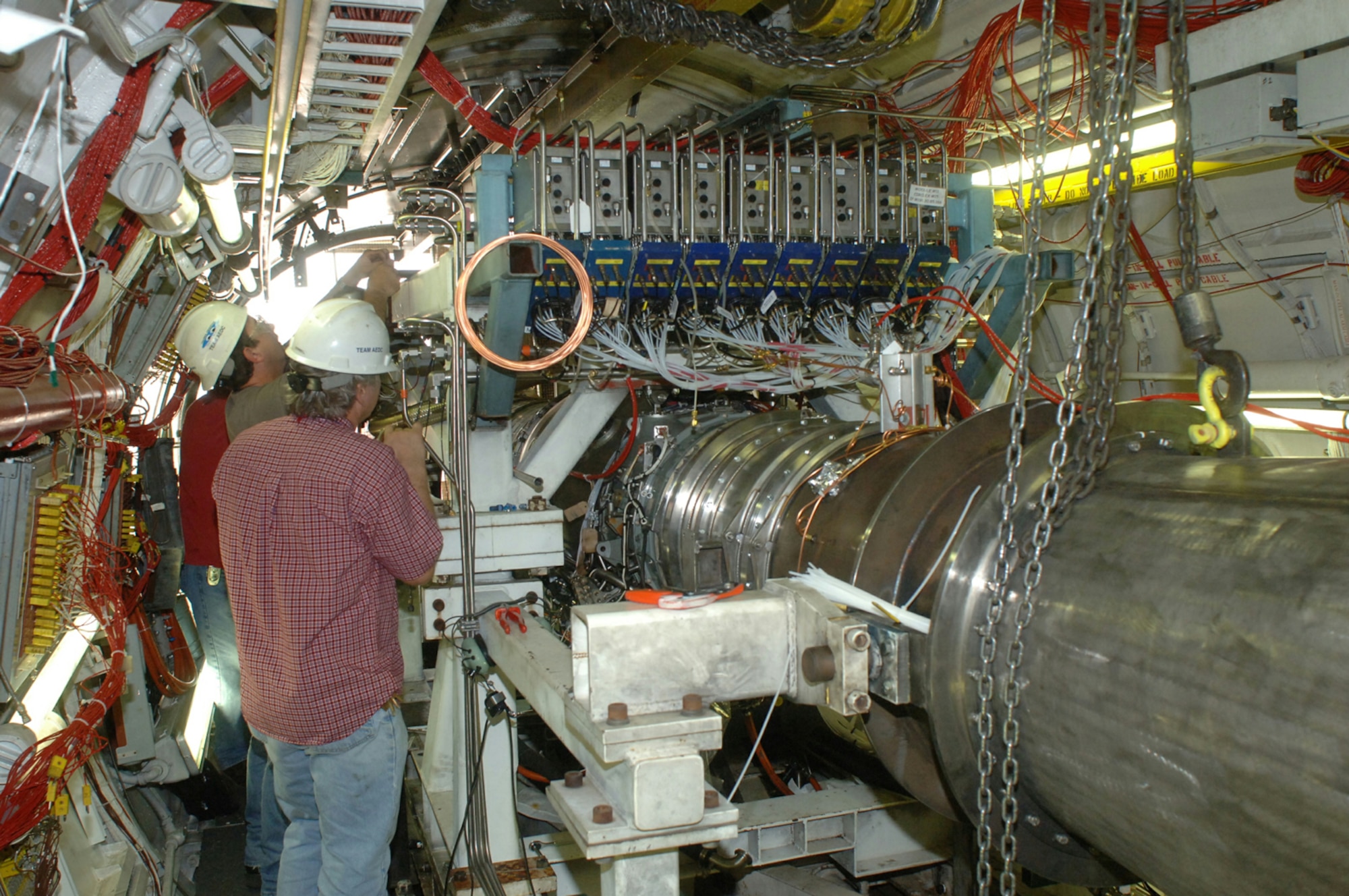 Aerospace Testing Alliance employees Steve Lawton, Brad Cantrell and Kenneth Rigsby install the cabin services bleed line on the Rolls-Royce F405-RR-402 engine in AEDC's T4 test cell. The F405 is the powerplant for the Navy T-45 Goshawk trainer.