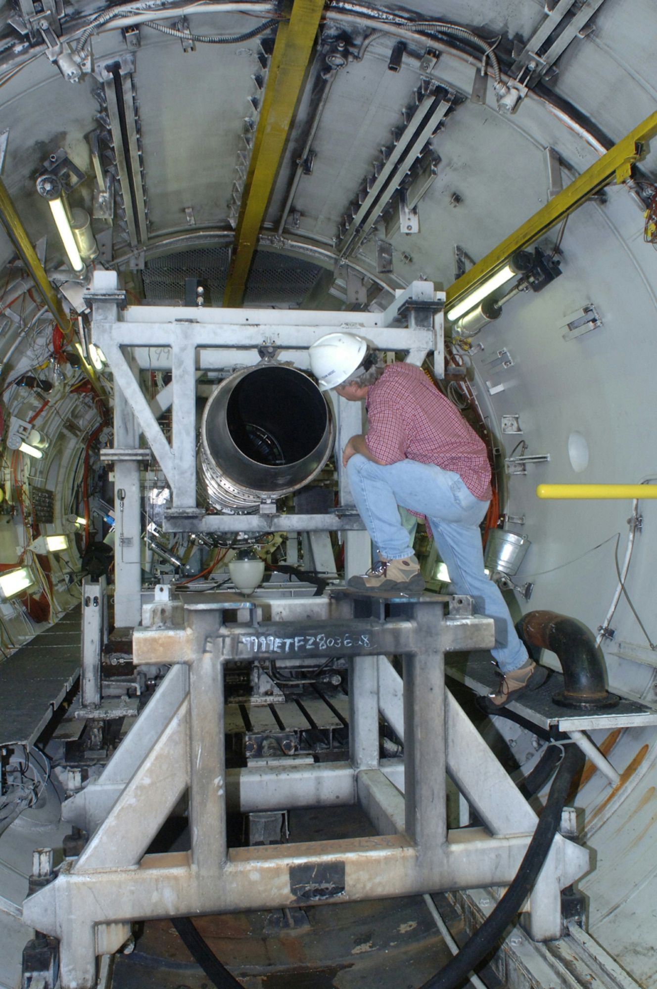 Steve Lawton, Aerospace Testing Alliance outside machinist, inspects the turbine and exhaust section of the Rolls-Royce F405-RR-402 engine in AEDC's T4 test cell. The F405 is the powerplant for the Navy T-45 Goshawk trainer. 