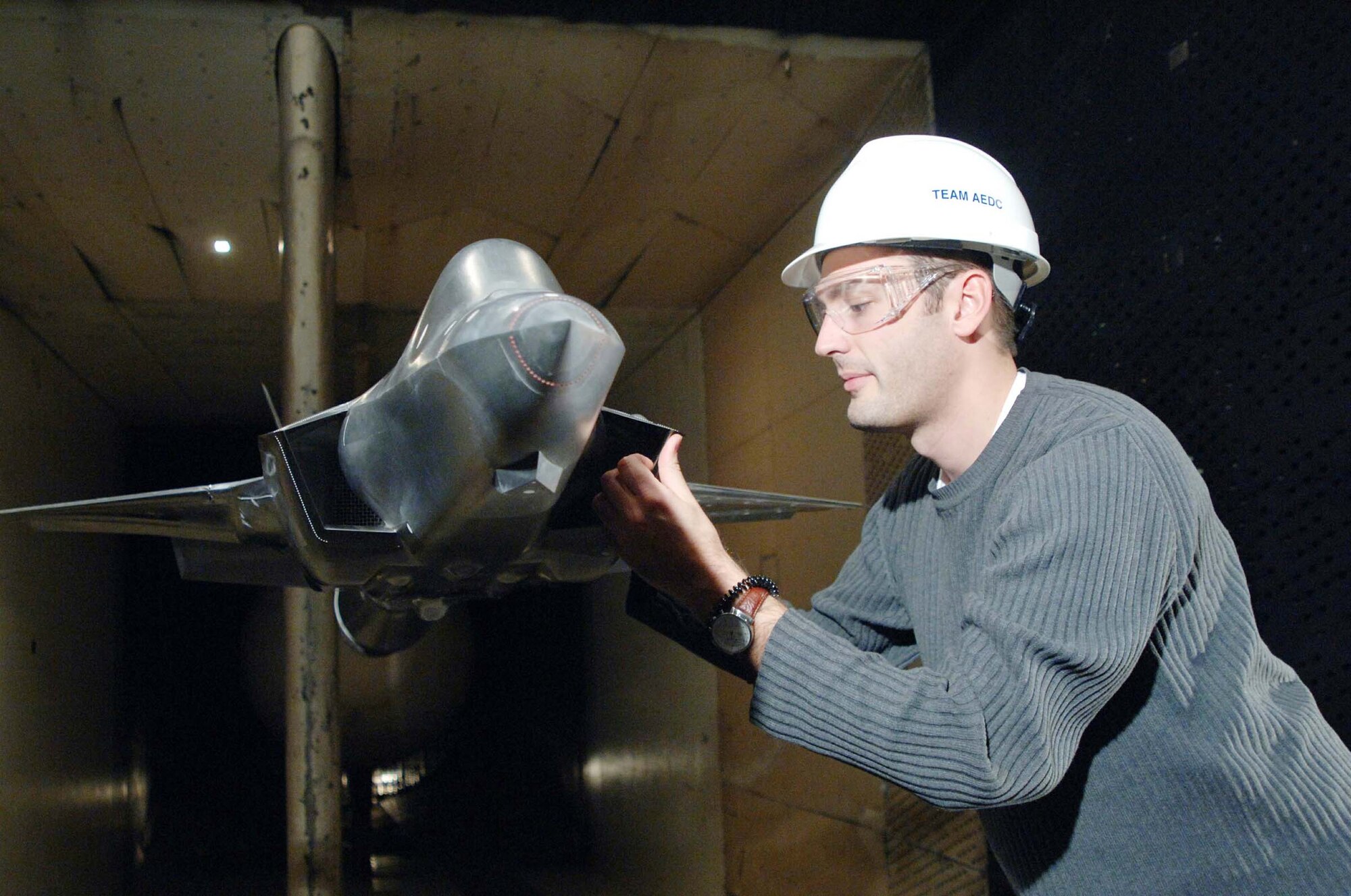 Chris Powell, a Lockheed Martin engineer, inspects the F-35 Joint Strike Fighter (JSF) model during a break in aerodynamics load testing in Propulsion Wind Tunnel’s 16-foot transonic wind tunnel. Arnold Engineering Development Center has played a key role in the development of the multi-service, multi-national JSF conducting aerodynamic and weapons separation wind tunnel testing as well as ongoing multi-year $200 million test program for the aircraft’s Pratt & Whitney F135 engine. The center is also scheduled to test alternate the Rolls-Royce/GE F136 engine.