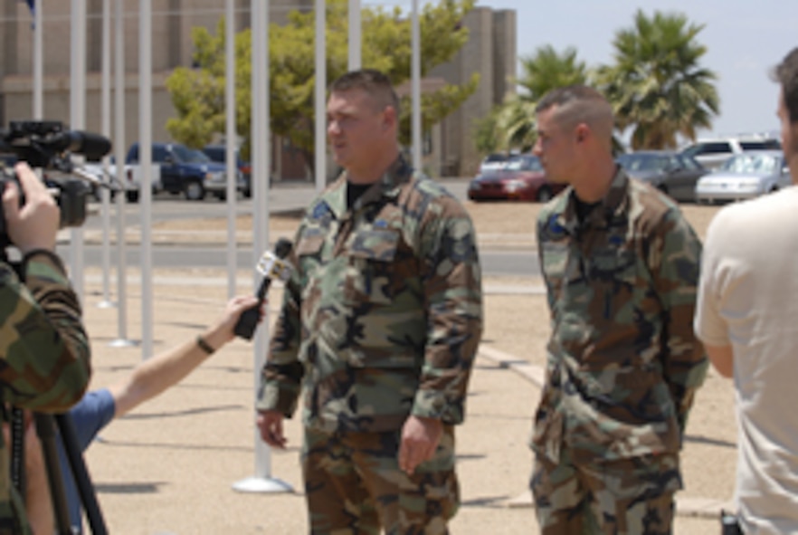 Tech. Sgt. James Orsund (left) and Staff Sgt. Christopher Anderson speak to reporters from the major Phoenix metro news stations about their experience saving children from an overturned truck after a car crash July 28.