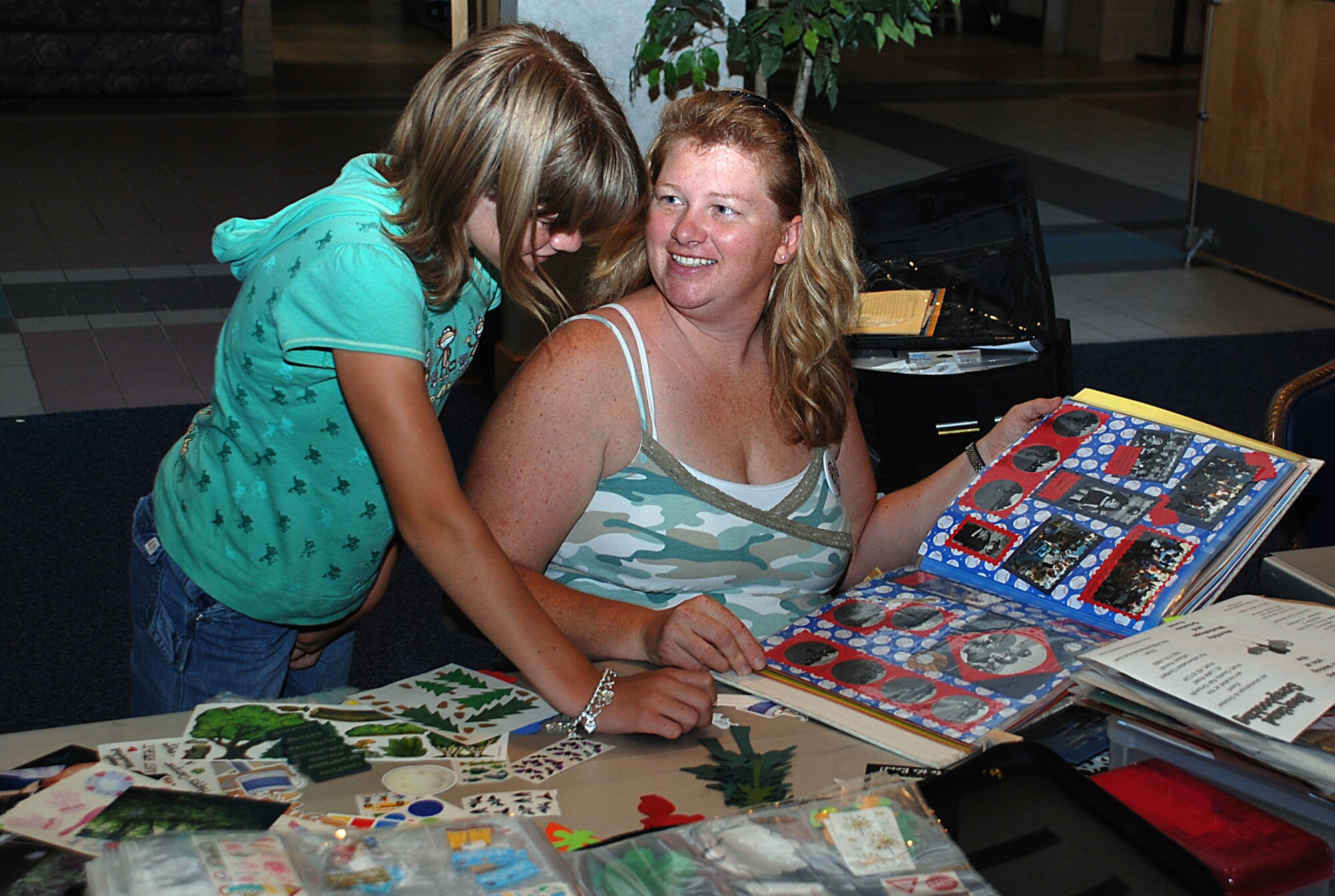 MCCONNELL AIR FORCE BASE, Kan. -- Army Staff Sgt. Richelle Phillips, 4204th Army Hospital Unit, Topeka, Kan., and Megan Dimmick, look at a photo album they put together at the scrapbook and rubber stamp crop event July 28 in the Dole Center ballroom. The event was hosted by the 22nd Services Squadron. Military members and families learned new scrap booking techniques and had the opportunity to win door prizes. The next scrapbook and rubber stamp crop event is scheduled Aug. 11 in the ballroom. For more information, call 759-4230. (Photo by Airman 1st Class Jessica Lockoski) 