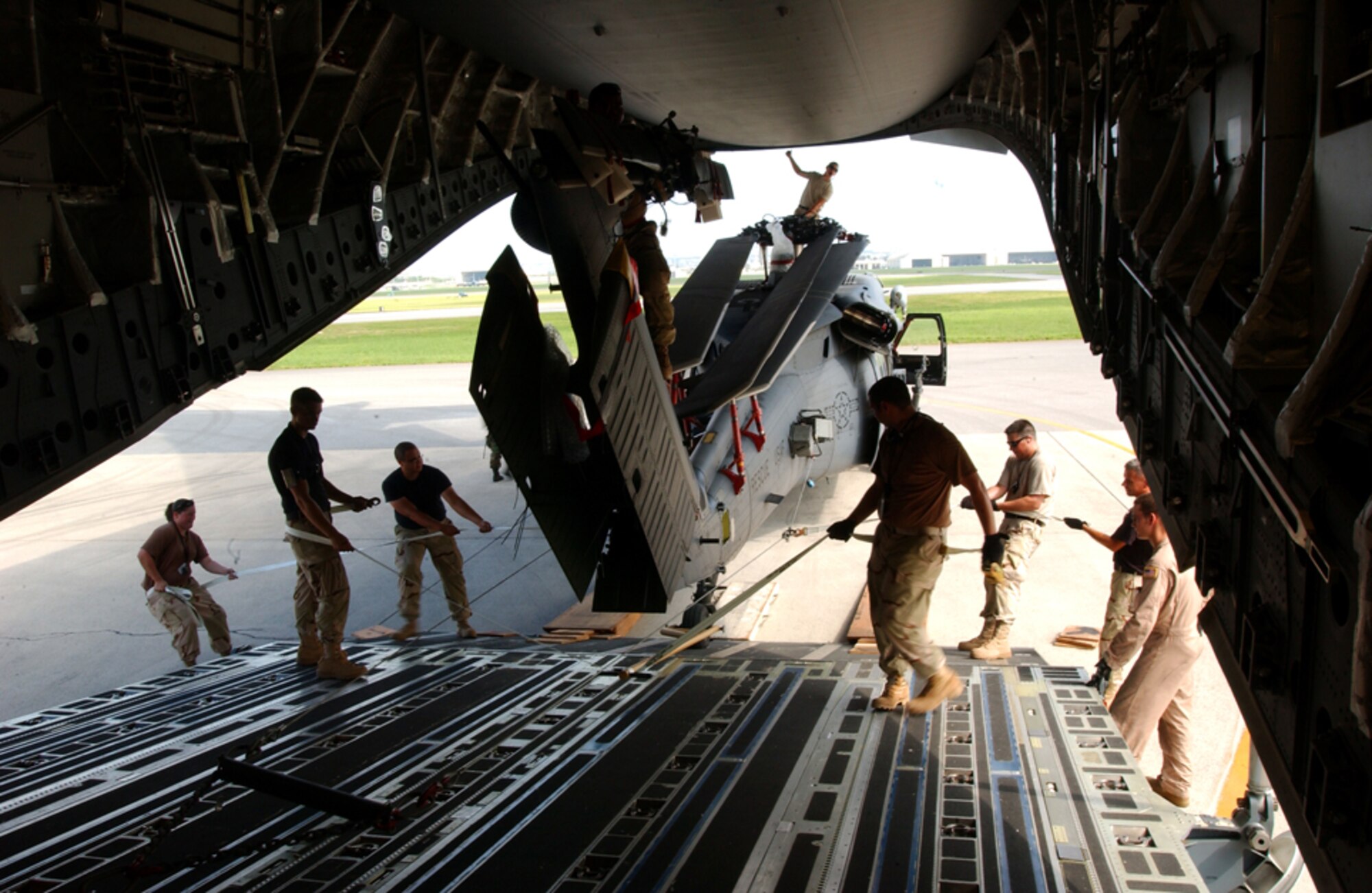 Airmen from the 33rd Rescue Squadron, Kadena Air Base, Japan, push one of two HH-60 Pave Hawk helicopters into a C-17 GlobeMaster July 30 in preparation for deployment to Kandahar, Afghanistan. This is the second time since January the squadron has deployed to Afghanistan. A group of squadron Airmen returned in May from a 4-month deployment to Kandahar, where this second group will conduct combat search and rescue and medical rescue missions in support of Operation Enduring Freedom. (U.S. Air Force photo/Staff Sgt. Reynaldo Ramon)


