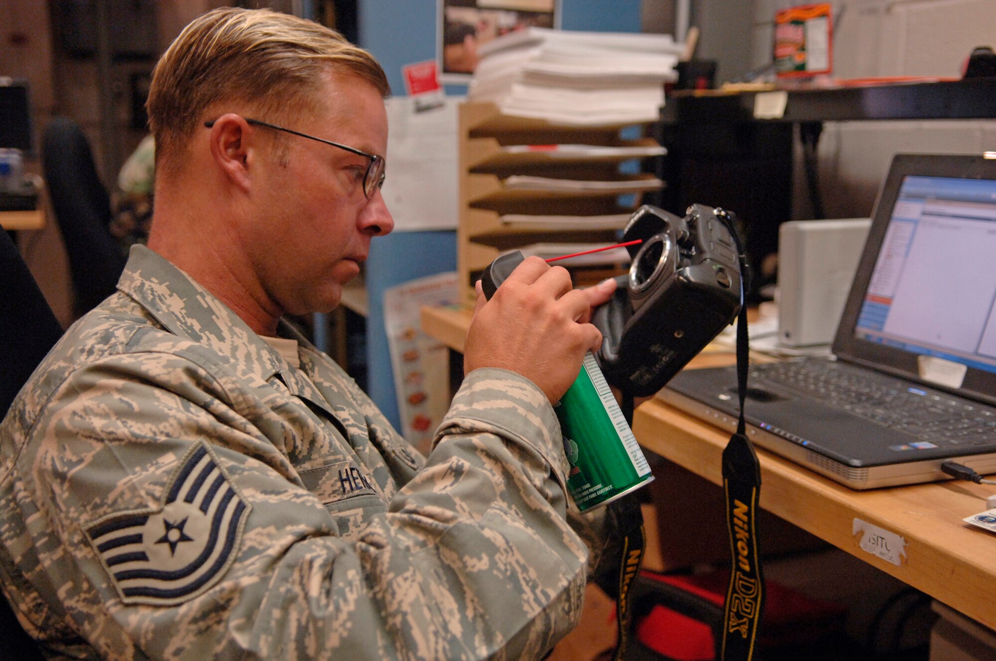 Tech Sgt. Paul Hendrix, 1st Combat Camera Squadron maintenance craftsman, wears the new Airmen Battle Uniform while cleaning a camera on base Tuesday. The new ABU is expected to be available to Airmen at military clothing sales on Charleston AFB this November or December. Currently any Airmen who deploy are issued the ABU for deployment. (U.S. Air Force Photo/Airman 1st Class Nicholas Pilch)