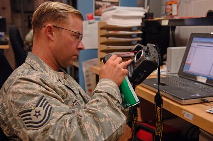 Tech Sgt. Paul Hendrix, 1st Combat Camera Squadron maintenance craftsman, wears the new Airmen Battle Uniform while cleaning a camera on base Tuesday. The new ABU is expected to be available to Airmen at military clothing sales on Charleston AFB this November or December. Currently any Airmen who deploy are issued the ABU for deployment. (U.S. Air Force Photo/Airman 1st Class Nicholas Pilch)