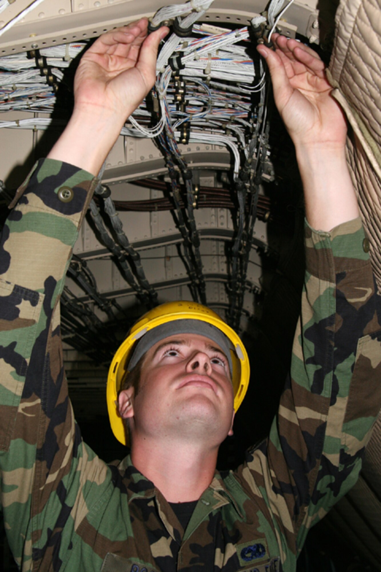 Senior Airman Marc Boone, 349th Equipment Maintenance Squadron Inspection Crew Chief for the Isochronal Inspections section at Travis AFB, Calif., inspects a C-5 interior fuselage electrical wiring for deterioration and to ensure wire clamps are undamaged and tight. The ISO inspection is a preventative maintenance inspection, done periodically to insure aircraft are ready for flight. When a C-5 enters the ISO hangar all aircraft systems such as avionics, electrical, hydraulic and aircraft fuel systems are inspected for complete functionality, component wear and over all structural integrity of the aircraft. (U.S. Air Force photo by Master Sgt. Wendy Weidenhamer)
