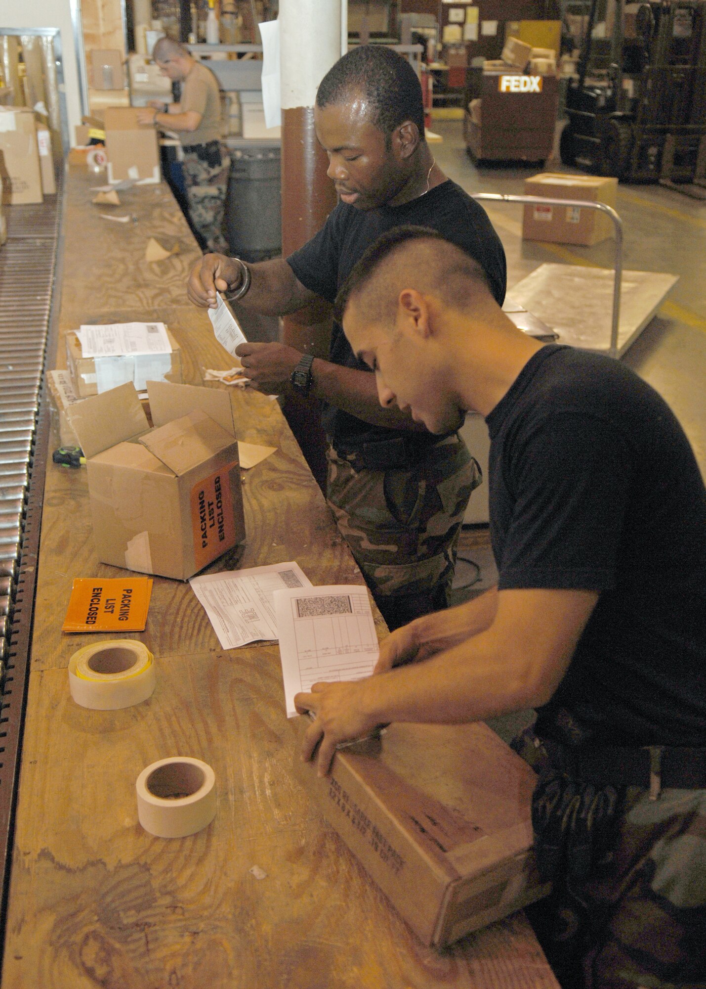 Airman 1st Class George Madrid and Airman 1st Class Baoz Pierre, 4th Logistics Readiness Squadron, Seymour Johnson AFB, North Carolina prepare boxes filled with aircraft parts for shipment on 1 August 2007.
(U.S. Air Force photo by Senior Airman Jessica Klingler)