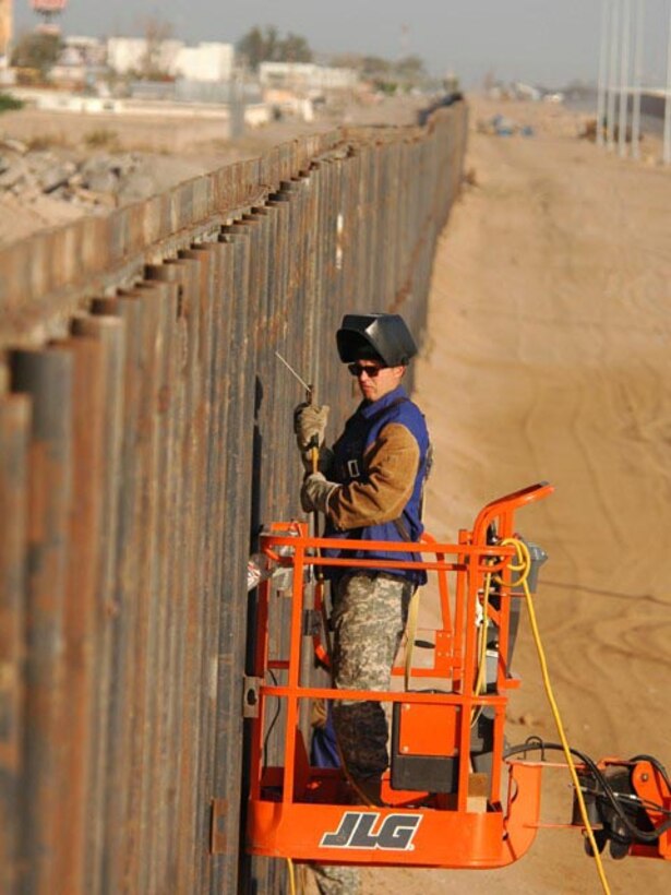 Army Specialist Michael J. Westall, 188th Engineer Company, applies a weld on the U.S. side of the primary border fence at the U.S.-Mexico border June 7, 2007.   Task Force Diamondback's mission is to erect and reinforce segments of border fence and the construction of obstacles to help secure the southwest United States-Mexico border.  (USAF photo/by Senior Master Sgt. David H. Lipp)