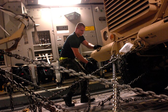 Airman 1st Class Michael Purcell chains down a Mine Resistant Ambush Protected armored vehicle on a C-17 Globemaster III at Charleston Air Force Base, S.C., for shipment to Iraq July 28. An estimated 3,500 MRAP vehicles are expected to be in Iraq by Dec. 31. Airman Purcell is assigned to the 437th Aerial Port Squadron. (U.S. Air Force photo/Tech. Sgt. Jeromy K. Cross) 

