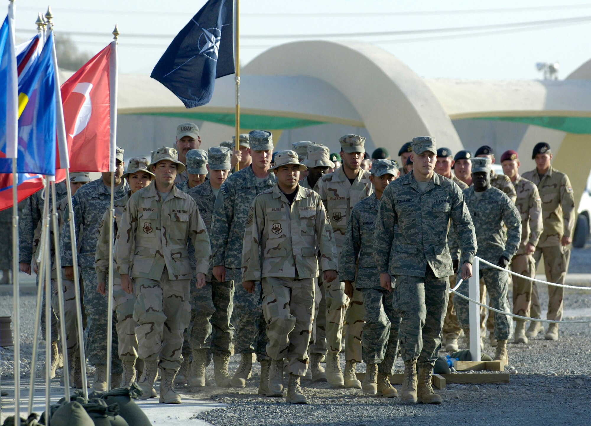 A military coalition honor flight marches on to the parade ground at Kandahar Air Field, Afghanistan, July 31 for a historic change-of-command ceremony that culminated a year-long effort to bring Kandahar under NATO control.  The ceremony marked the first time NATO has taken full control of a large airfield and operational staging base in an active operational theater using a multi-national team. (U.S. Air Force photo/Master Sgt. Jim Varhegyi)