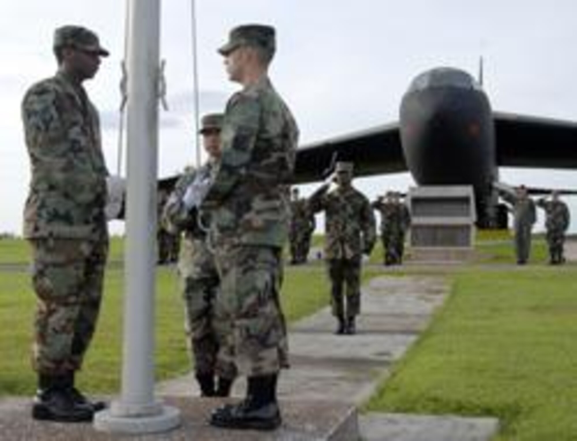 ANDERSEN AIR FORCE BASE, Guam - Members of the Andersen Honor Guard and Air Force Office of Special Investigation, Detachment 602, conduct reveille in front of Arc Light Memorial park on Andersen Air Force Base commemorating the 60th Anniversary of AFOSI.  Situated across the Pacific dateline, Det 602 is the first AFOSI detachment to raise the flag during the year-long celebration.  (Graphic by Maj R.A. Dowdell)