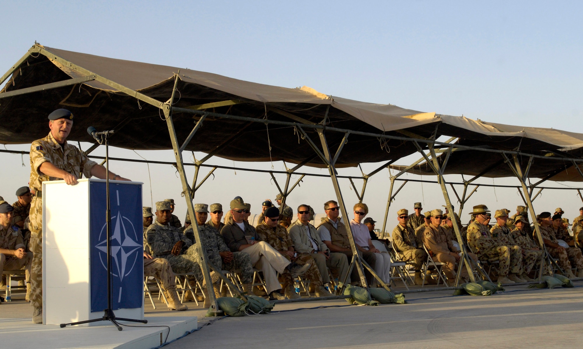 Royal Air Force Air Commodore Ashley Stevenson addresses the assembly after taking command of Kandahar Air Field, Afghanistan, July 31.  The historic change-of-command ceremony culminated a year-long effort to bring Kandahar under NATO control.  The ceremony marked the first time NATO has taken full control of a large airfield and operational staging base in an active operational theater using a multi-national team. (U.S. Air Force photo/Master Sgt. Jim Varhegyi)