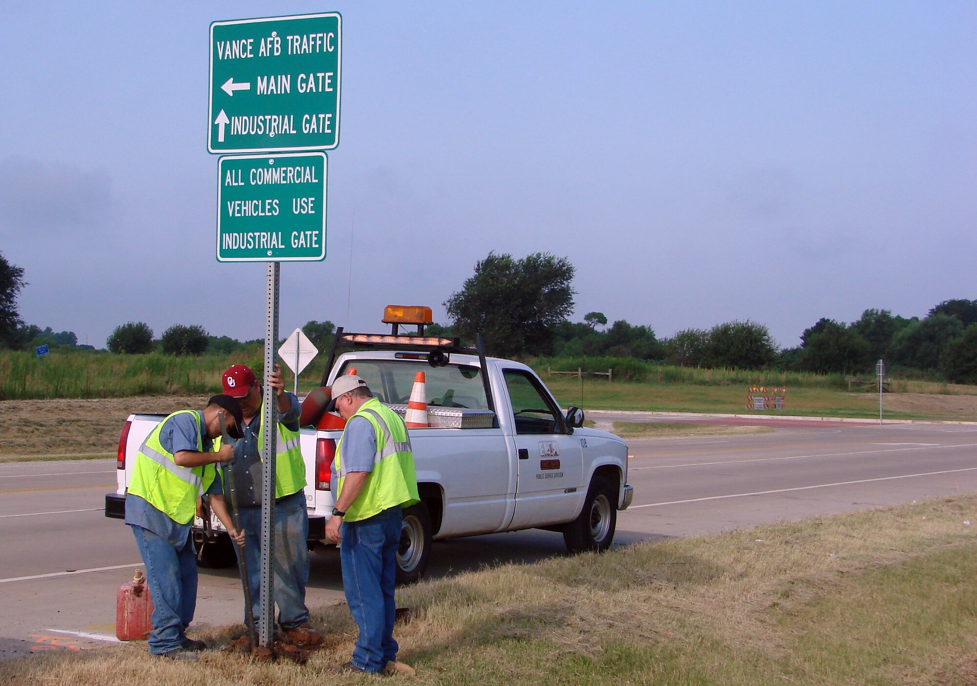 Mike Aguilar, Mike Goodpasture and Bill Hawkins, City of Enid Division of Traffic Control, erect a sign on Southgate Road directing traffic to Vance Air Force Base. The traffic flow pattern to the base changes Aug. 16 when drivers coming to Vance from Van Buren Street will come to the Main Gate via Southgate and Gott Roads. Drivers coming from Cleveland St. will be able to access the base via the Industrial/West Gate during duty hours.  After duty hours, Industrial/West Gate and the perimeter fence access gate on Cleveland will be closed, requiring all vehicle traffic to access the base via Southgate. Drivers should be prepared for traffic delays during this transition period and should plan accordingly.            