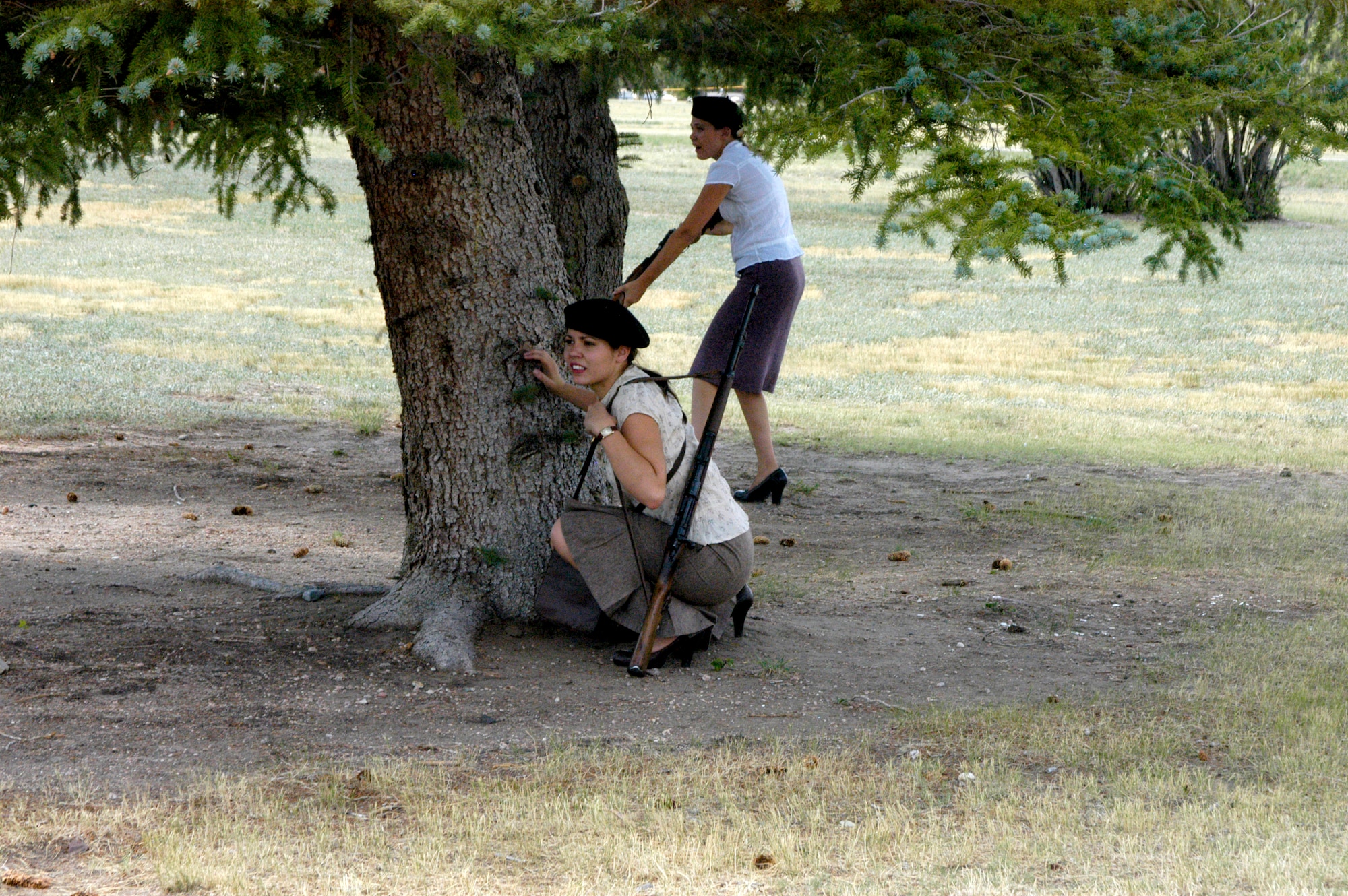 Brianna and Tiani Cook, performing as two French resistance members, prepare to sabotage the German’s communication line while the Germans aren’t looking during a World Ware II re-enactment on base Sunday. This particular battle was fictional but uses accurate equipment and dress for the period.