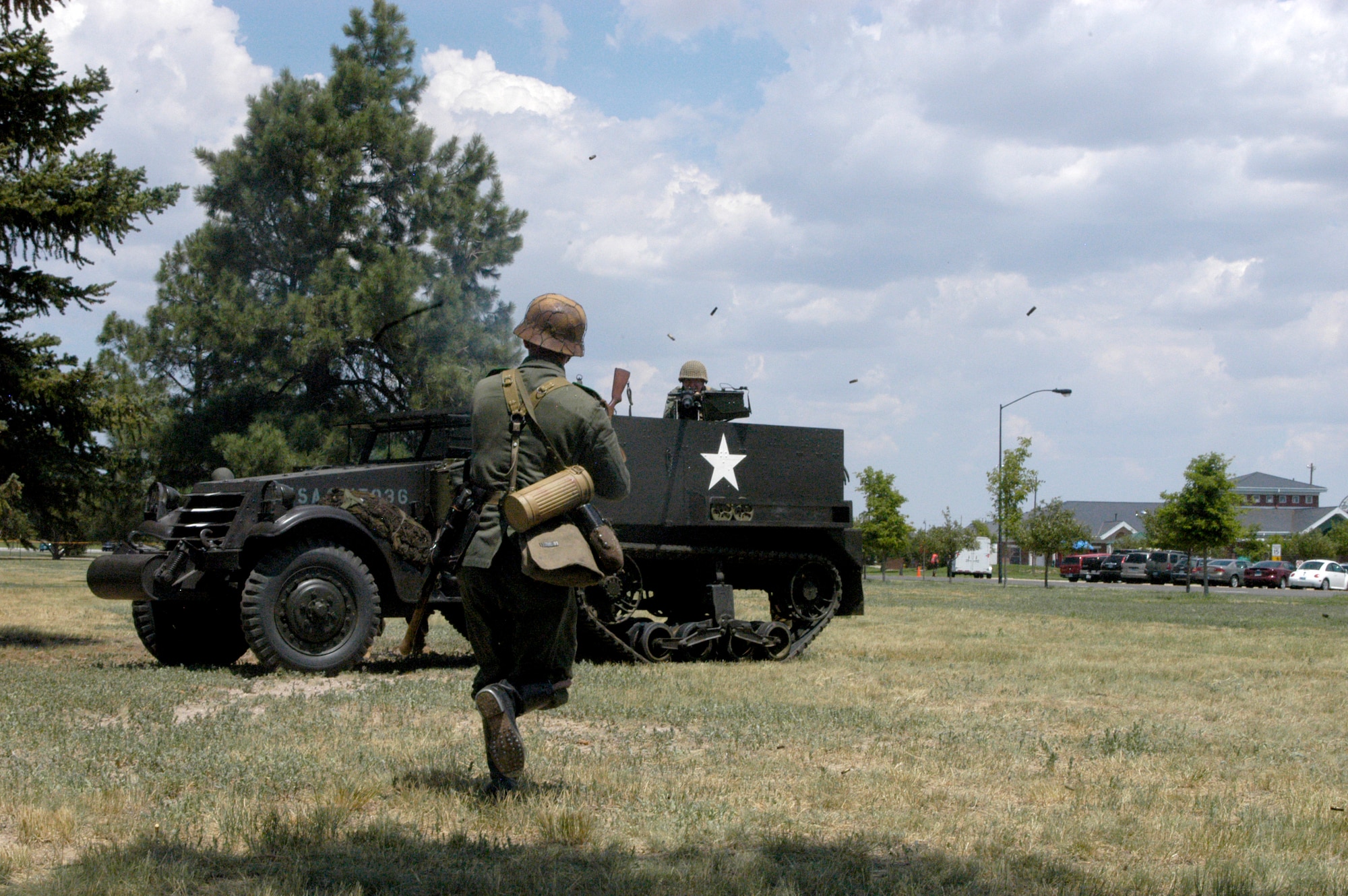 Andrew Camp, playing as a German, is “gunned down” by Jonnie Johnson manning the American half-truck during his suicide run near Argonne Parade Field here Sunday. The American and German camps at Fort D.A. Russell Days here performed a fictional World War II skirmish using authentic clothing and weapons (Photos by 2nd Lt. Lisa Meiman).
