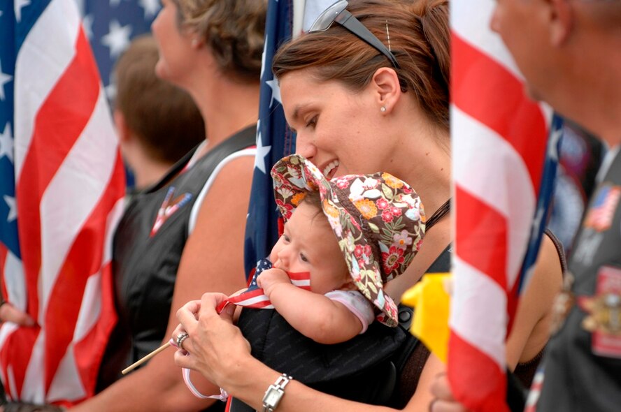Melissa Smith, a member of the Patriot Guard Riders, waits with her son Teaghan at Ellsworth Air Force Base, S.D., for the return of 28th Bomb Wing Airmen after their 6 month deployment to Southwest Asia in support of Operations IRAQI FREEDOM and ENDURING FREEDOM, July 27, 2007.  The Patriot Guard Riders are a group of motorcycle riders that attend military events to show respect and shield the service member and family from interruptions caused by protestors.  (U.S. Air Force photo by SSgt Michael B. Keller)(Released by TSgt Steven Wilson, 28th BW/PA)