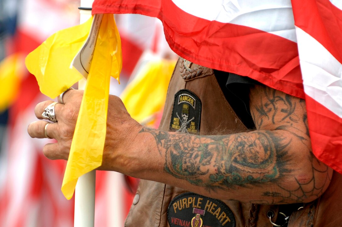 Patriot Guard Rider “Bear” displays signposts detailing his military service on his riding vest as he waits at Ellsworth Air Force Base, S.D., for the return of 28th Bomb Wing Airmen, July 27, 2007. During the Airmen’s 6 month deployment to Southwest Asia they supported combat operation for Operations IRAQI FREEDOM and ENDURING FREEDOM. The Patriot Guard Riders are a group of motorcycle riders that attend military events to show respect and shield the service member and family from interruptions caused by protestors.  (U.S. Air Force photo/Staff Sgt. Michael B. Keller)(Released by Tech. Sgt. Steven Wilson, 28th BW/PA)

