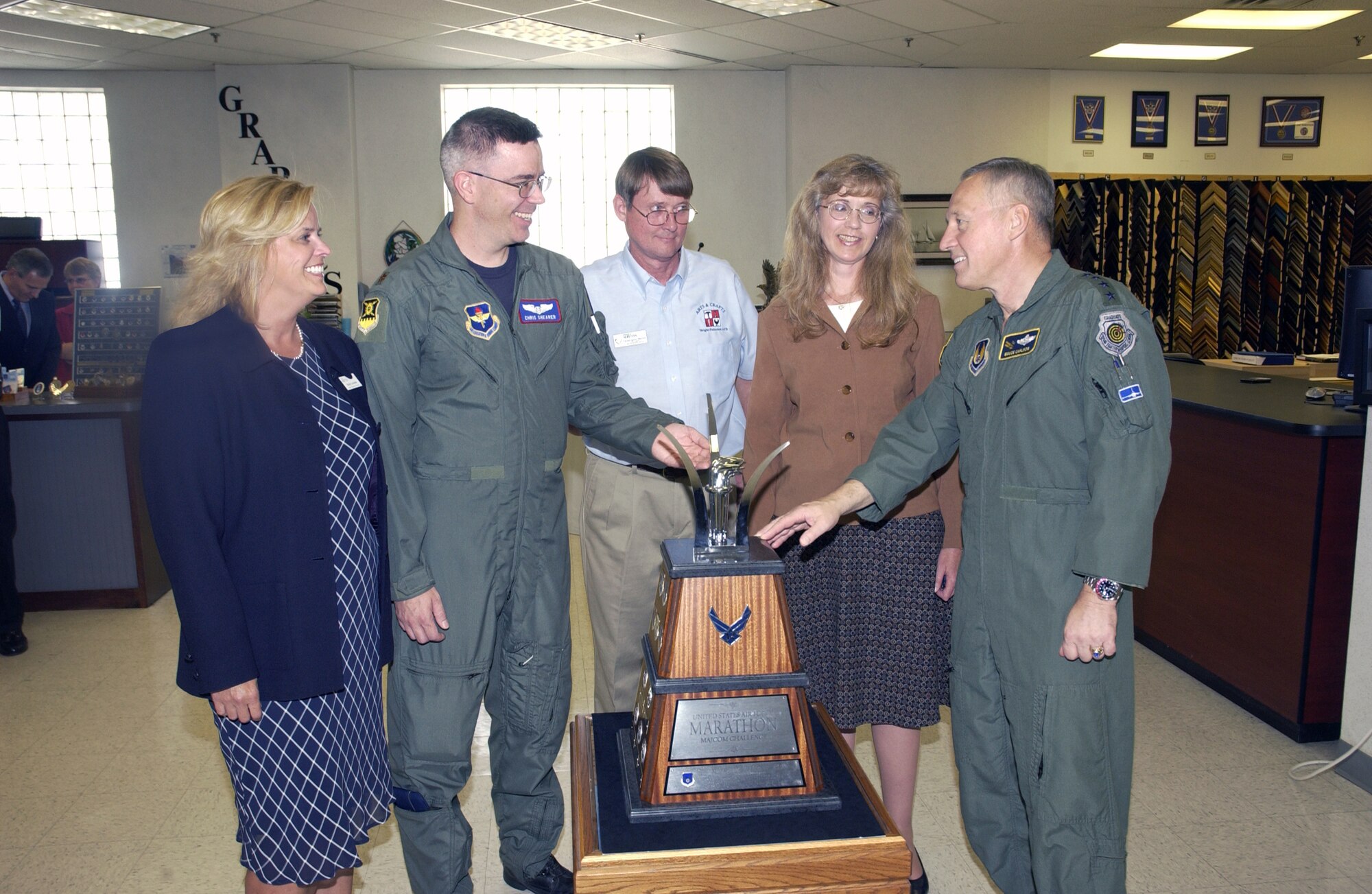 Gen. Bruce Carlson, commander of Air Force Materiel Command (far right), speaks with some of the people behind the MAJCOM Challenge trophy, to be awarded for the first time at this year's U.S. Air Force Marathon on Sept. 15. Pictured from left to right: Molly Louden, marathon director; Maj. Christopher Shearer, design team; Christopher Barrett, craftsman; and Mary Ann Kloss, principle designer. Other contributors to the trophy's creation not pictured include: Mike Eckes, craftsman; Don Lindsly, craftsman; Laura Romesburg, funding; Jack Weber, funding; and Chris Zickefoose, design team.  (Air Force photo by Michael Libecap)