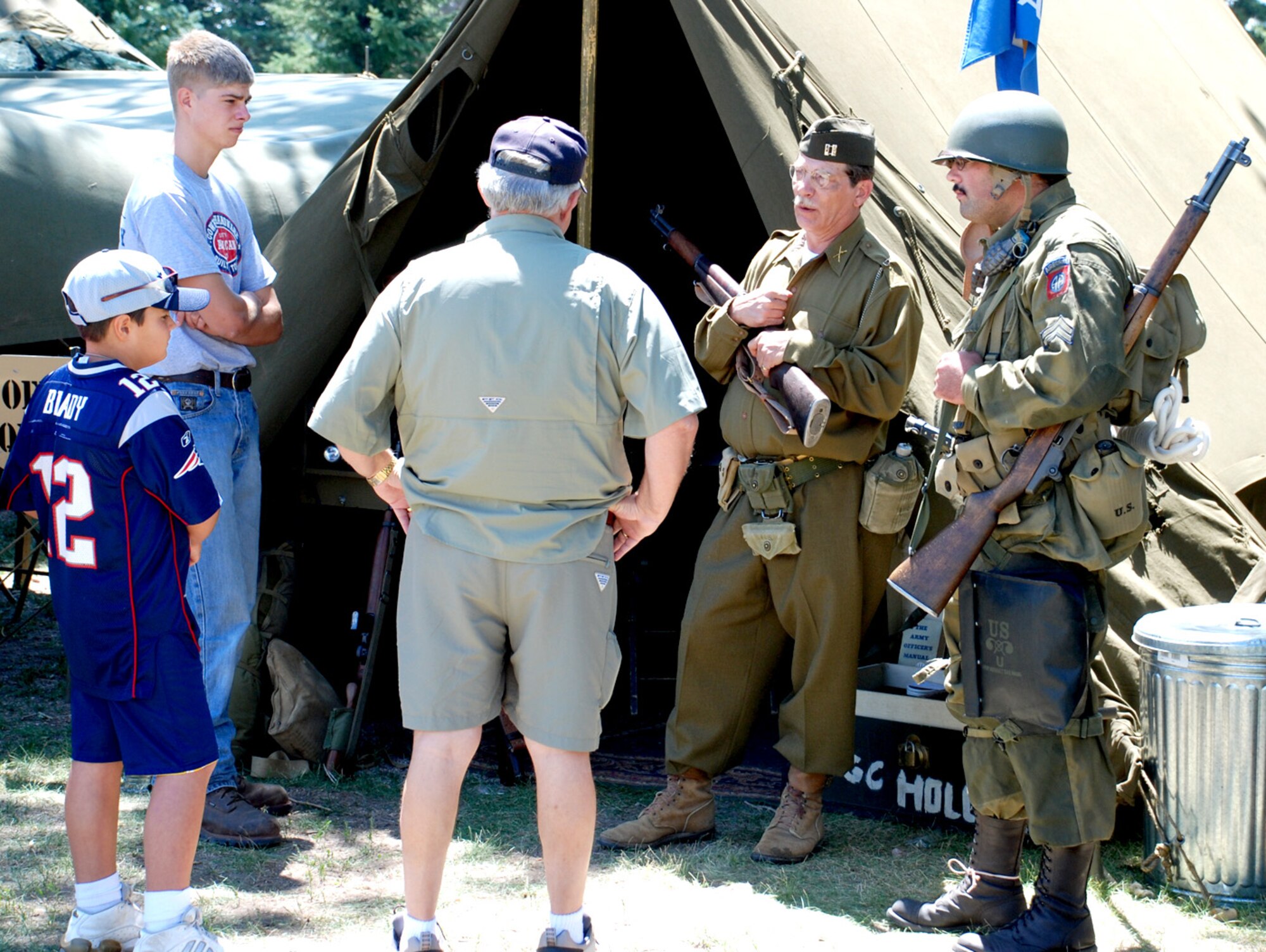 Presley Pace (far right) and Lanier Lucas describe what it might have been like to be at a World War II encampment during a living history re-enactment at Fort D.A. Russell Days here July 20. Some of the tents on display were a communications tent, orderly room, company command tent, officers quarters, enlisted camp, medical tent and a post exchange (Photo by Staff Sgt. Chad Thompson).