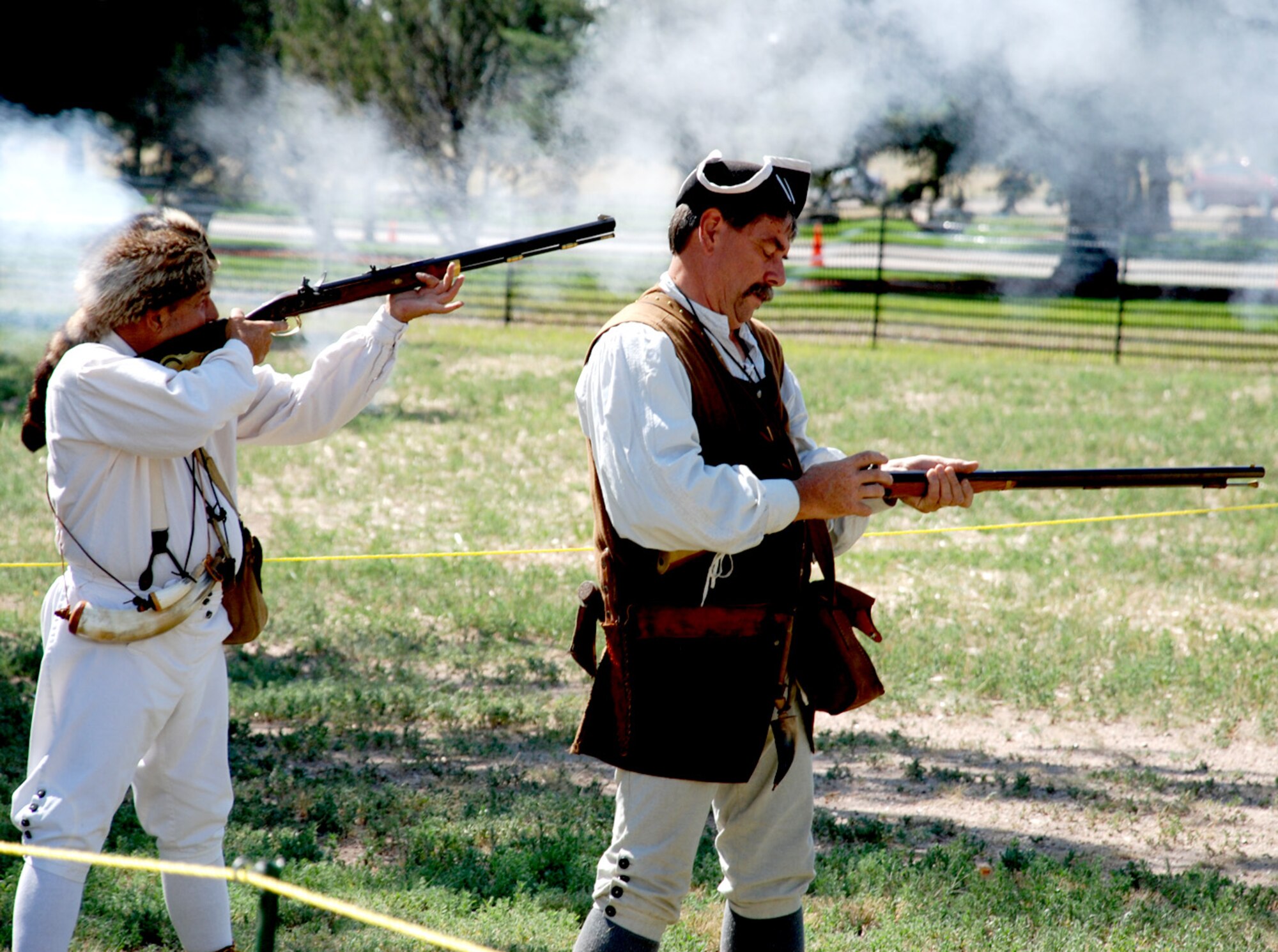 Dave Lesure and Rod Bergstrom, members of the Northern Colorado Fife and Drum Corps, test fire their black powder muskets to ensure they are in working order here July 20. Muskets can be greatly affected during rain, high winds and humidity due to the use of gun-powder and flint. Such problems cause the weapon to “flash the pan,” or misfire (Photo by Staff Sgt. Chad Thompson).