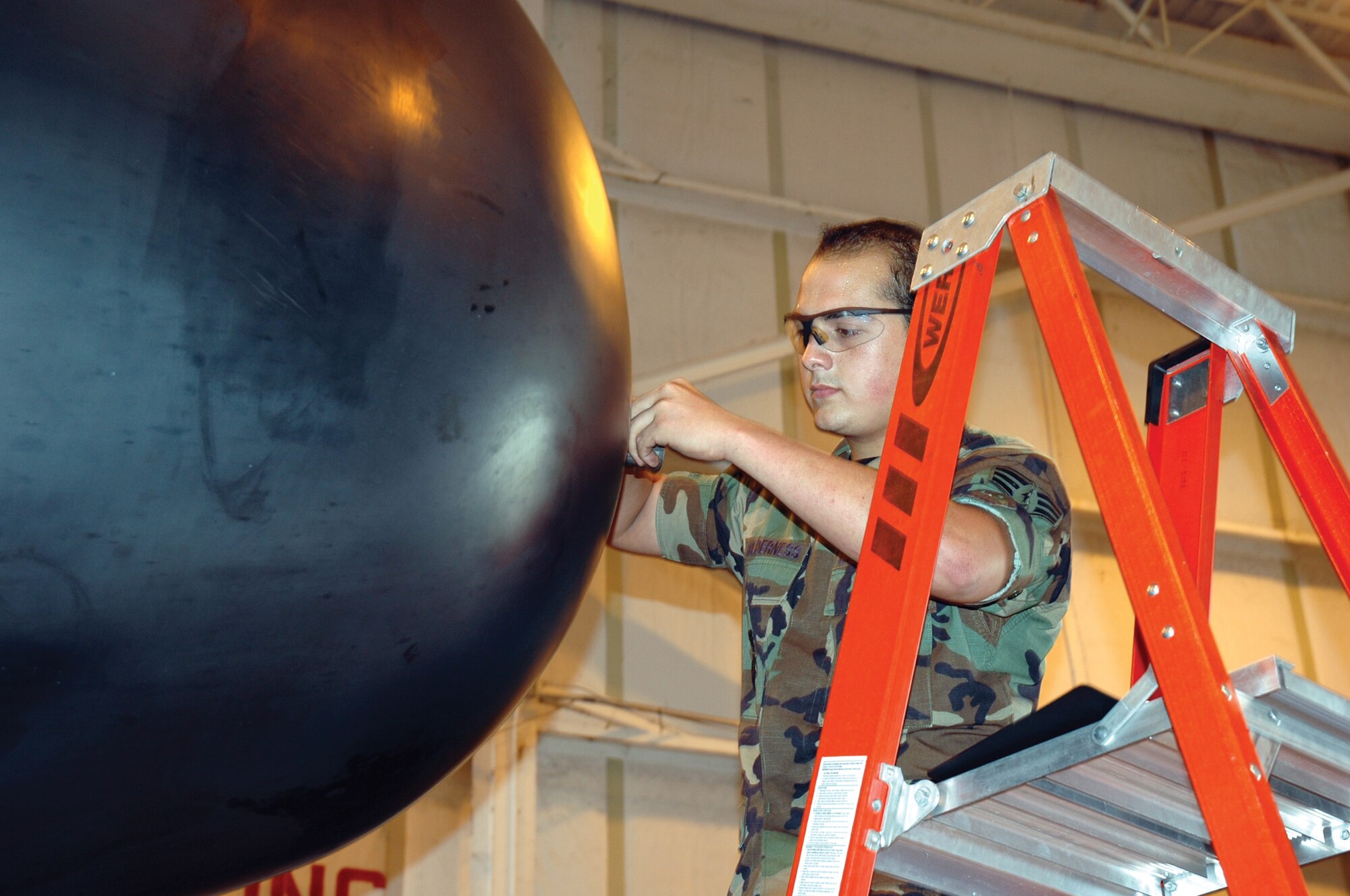 Senior Airman Jonathan Holderness, 919th Maintenance Squadron aircraft inspector, inspects the condition of the safety wire on a nose radome anti-icing nozzle on an MC-130E Combat Talon I aircraft in the Isochronal Hangar. This annual maintenance inspection is conducted to ensure the security of the nozzle during flight. (U.S. Air Force Photo\Senior Airman Erik Hofmeyer)
