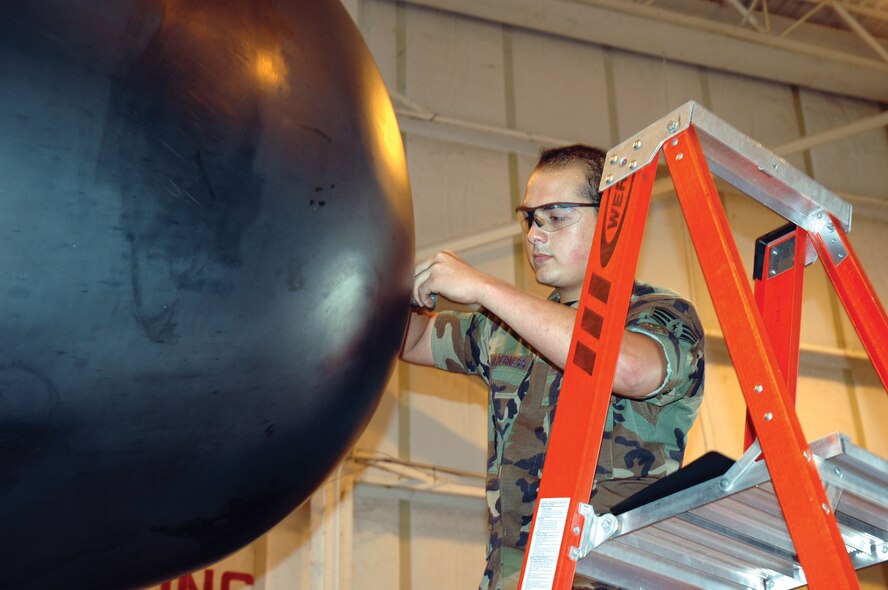 Senior Airman Jonathan Holderness, 919th Maintenance Squadron aircraft inspector, inspects the condition of the safety wire on a nose radome anti-icing nozzle on an MC-130E Combat Talon I aircraft in the Isochronal Hangar. This annual maintenance inspection is conducted to ensure the security of the nozzle during flight. (U.S. Air Force Photo\Senior Airman Erik Hofmeyer)
