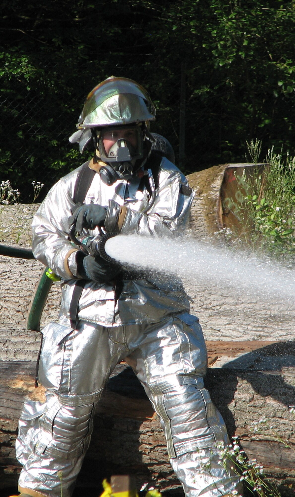 SPANGDAHLEM AIR BASE, Germany – Frank Weis, 52nd Civil Engineer Squadron firefighter, extinguishes a fire during a simulated C-17 crash at Oberweis near Bitburg Annex. The emergency management exercise was designed to test the 52nd Fighter Wing emergency response capability. (U.S. Air Force photo/Master Sgt. George King)