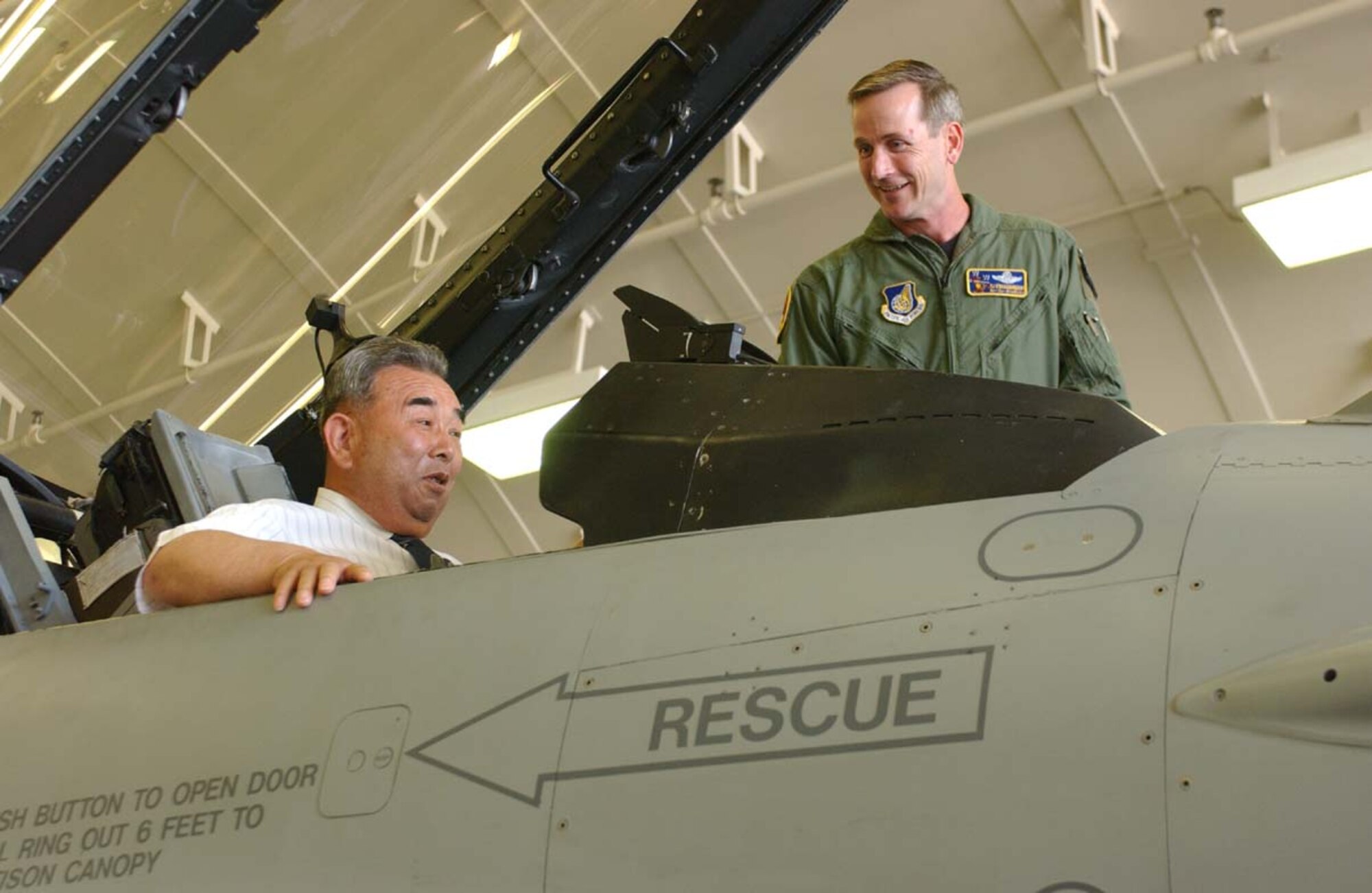 MISAWA AIR BASE, Japan -- Mayor Kazumasa Taneichi, the new Misawa City maor, is treated to a seat in the cockpit of the 35th Fighter Wing Commander Col. Terrence O'Shaughnessy's (right) F-16 Fighting Falcon July 26. After 67 years of living next door, the mayor set foot on the the base for the first time. The mayor received a tour of the flightline, fire station, new dorms, and Grissom Dining Facility. The mayor then enjoyed lunch at the Officer's Club with base leadership and gained a better understanding of 35th Fighter Wing's mission. (U.S. Air Force photo by Airman 1st Class Benjamin Wilson)
