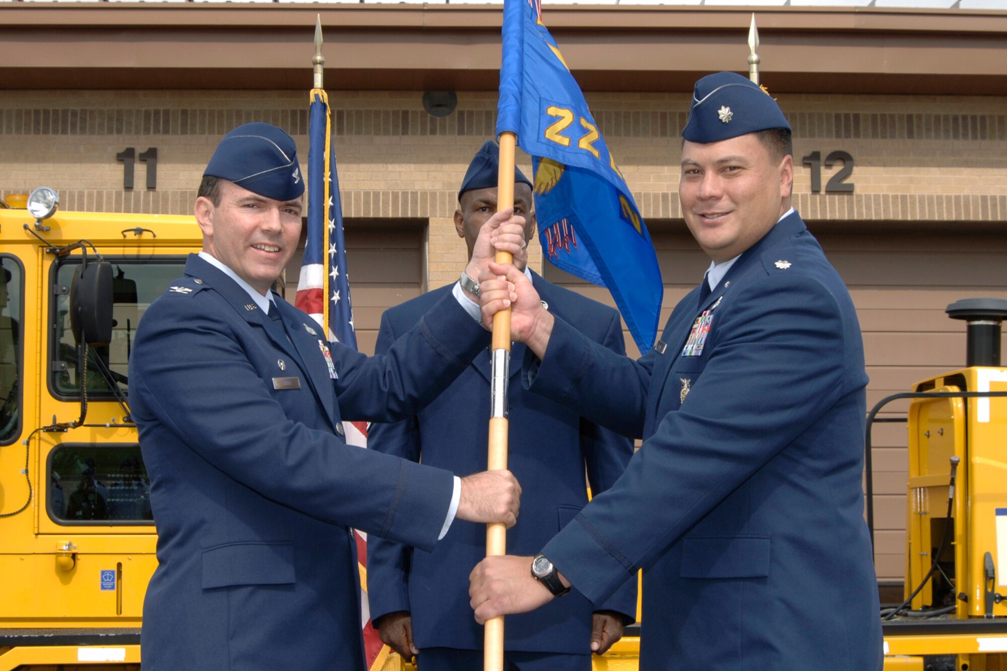 MCCONNELL AIR FORCE BASE, Kan. -- Col. Mark White, left, 22nd Mission Support Group commander, hands the 22nd Civil Engineer Squadron guidon and command of the squadron to Lt. Col. Aaron Young July 31 during an assumption of command ceremony here. Colonel Young succeeded Lt. Col. Nam Shelton as 22nd CES commander. (Photo by Senior Airman Jamie Train)