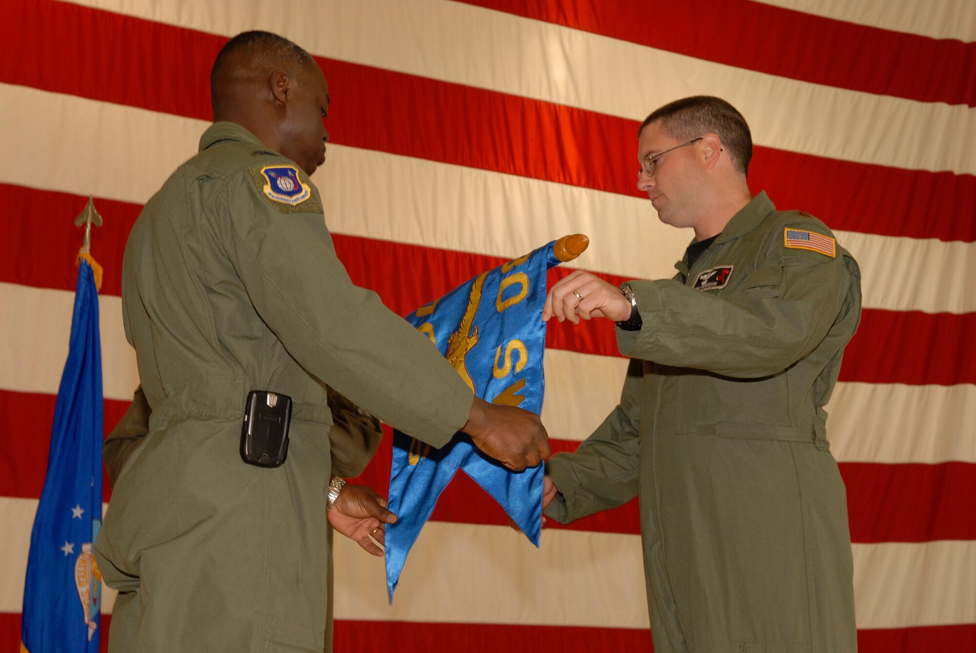 VANDENBERG AIR FORCE BASE, Calif. -- 30th Operations Group Commander Col. Andre Lovett furls the 76th Helicopter Squadron's guidon flag with the unit's final commander during the 76th HS inactivation ceremony at the hangar on Aug. 2.  The squadron supported space launch, land and water rescue, fire suppression and many diverse training missions.  (U.S. Air Force photo/Airman 1st Class Adam Guy)