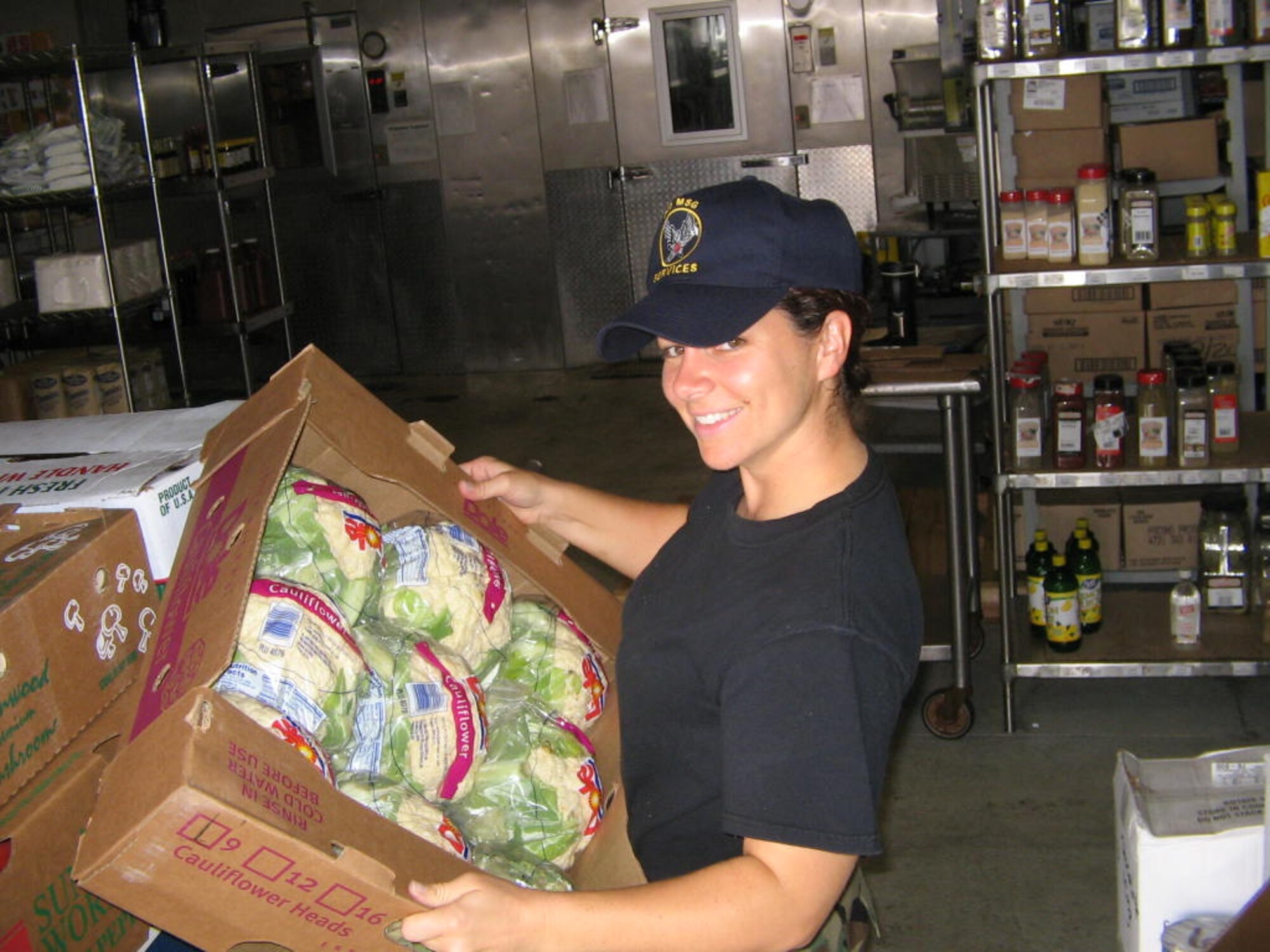 Tech. Sgt. Katie Coyle, NCO in charge of the 305th Services Squadron dining facility, stocks a produce order July 20.  (Courtesy photo)