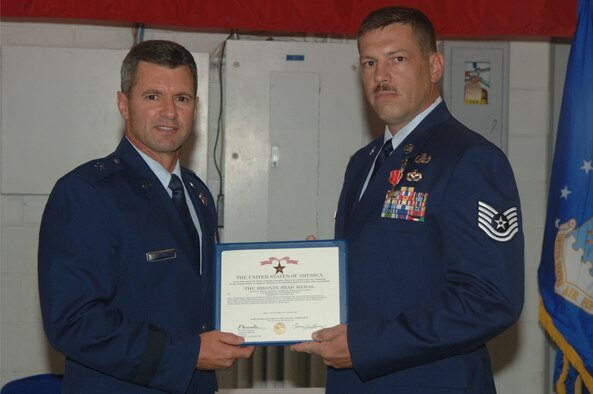 WHITEMAN AIR FORCE BASE, Mo. - Brig. Gen. Greg Biscone, 509th Bomb Wing commander, presents Tech. Sgt. Michael Shumate, 509th Civil Engineering Squadron, with a Bronze Star Medal July 30 at the CE high bay. Sergeant Shumate was awarded the medal for his exceptional service during Operation Iraqi Freedom. (U.S Air Force photo/Staff Sergeant Felicia Haecker)