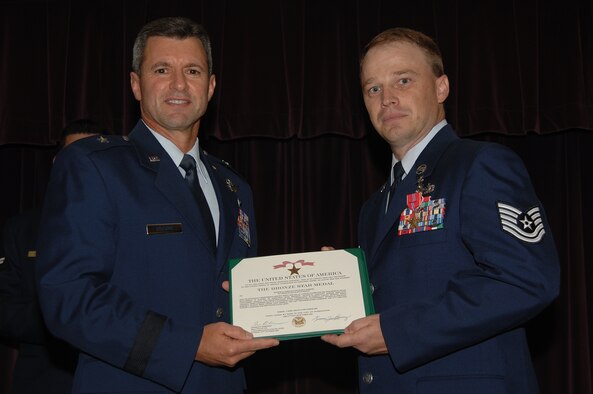 WHITEMAN AIR FORCE BASE, Mo. - Brig. Gen. Greg Biscone, 509th Bomb Wing commander, presents Tech. Sgt. Richard Barker, 509th Logistics Readiness Squadron, with a Bronze Star Medal July 20 at the Mission’s End. Sergeant Barker was awarded the medal for his exceptional service during Operation Iraqi Freedom. (U.S. Air Force photo/Senior Airman Lauren Padden)   