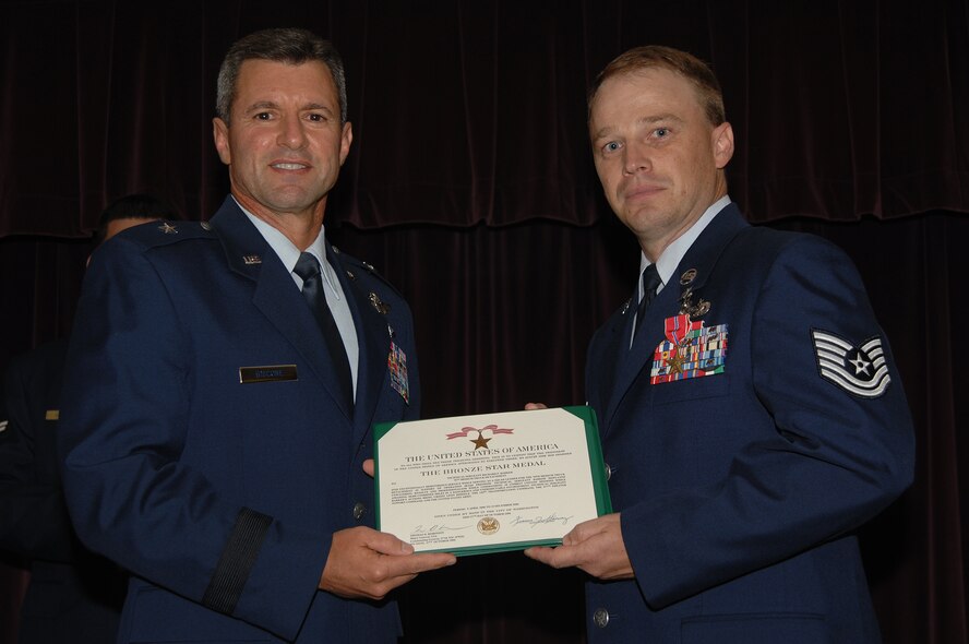 WHITEMAN AIR FORCE BASE, Mo. - Brig. Gen. Greg Biscone, 509th Bomb Wing commander, presents Tech. Sgt. Richard Barker, 509th Logistics Readiness Squadron, with a Bronze Star Medal July 20 at the Mission’s End. Sergeant Barker was awarded the medal for his exceptional service during Operation Iraqi Freedom. (U.S. Air Force photo/Senior Airman Lauren Padden)   