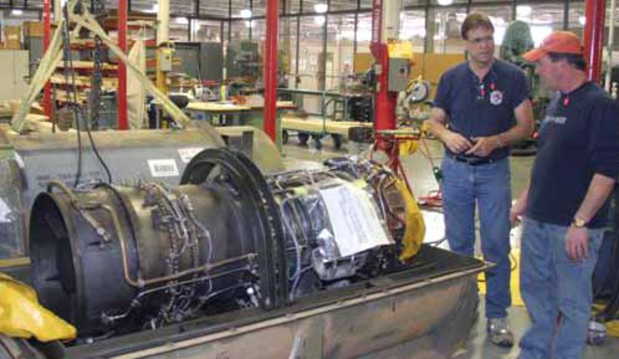 Woodworker Howard Holinsworth, left, and packaging specialist T.C. Jones, discuss a special packaging instruction design for a T-64-100 engine. (Courtesy Photo)