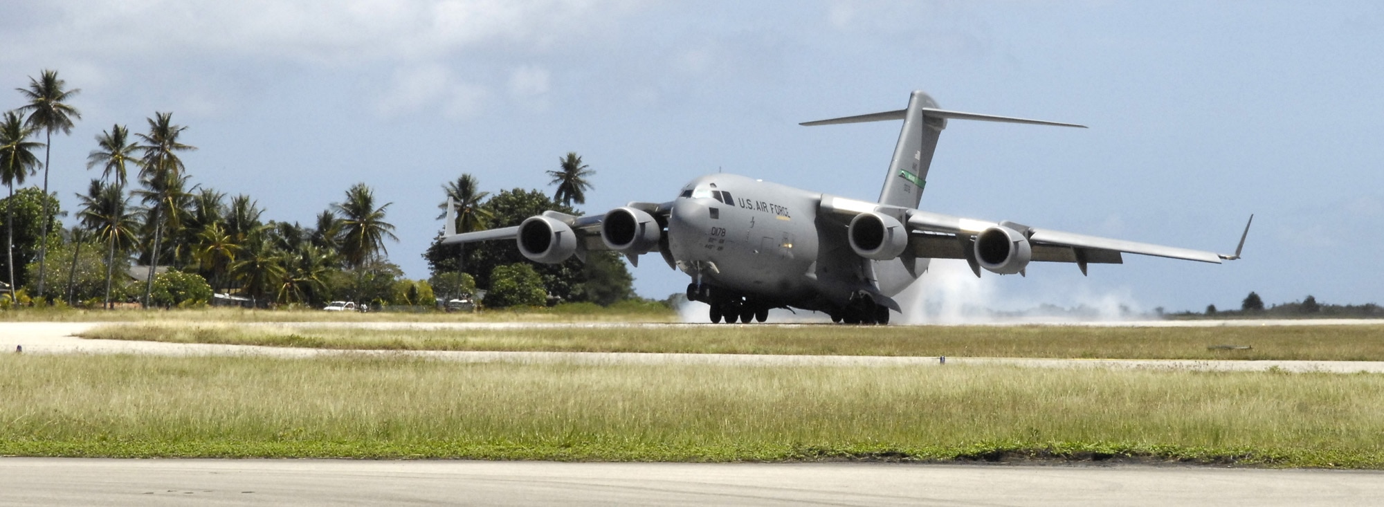 REPUBLIC OF NAURU – A C-17 Globemaster III piloted by a crew from the 728th Airlift Squadron of McChord Air Force Base, Wash. lands here July 27. The C-17 picked up a 12-person team of U.S. Pacific Command Airmen and Soldiers deployed here to provide medical assistance and training to the island's caregivers. This was the first time a substantial U.S. military presence has been to Nauru since World War II. A thick reef surrounds the island, precluding ships from docking, and the runway is relatively short. The C-17's unique ability to land on short runways made this mission possible. (U.S. Air Force photo/Tech. Sgt. Chris Vadnais)