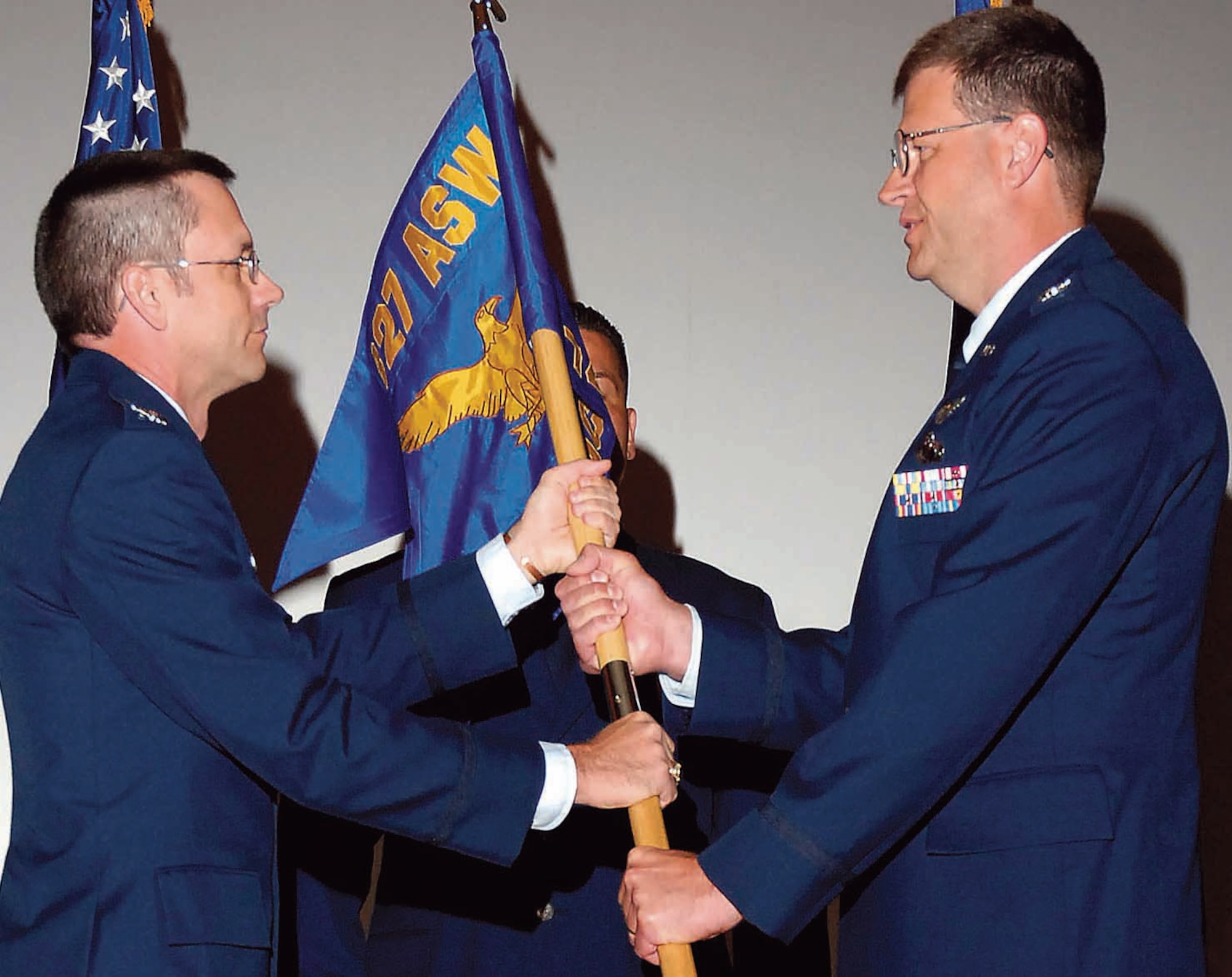 with the traditional guidon presentation, Col. Keith Weyenberg, right, accapts command of the 747th Aircraft Sustainment Group. Col. Paul Waugh, 327th Aircraft Sustainment Wing commander, assigned Col. Weyenberg as group commander during the July 24 ceremony in the base theater. (Air Force photo by Dave Faytinger)