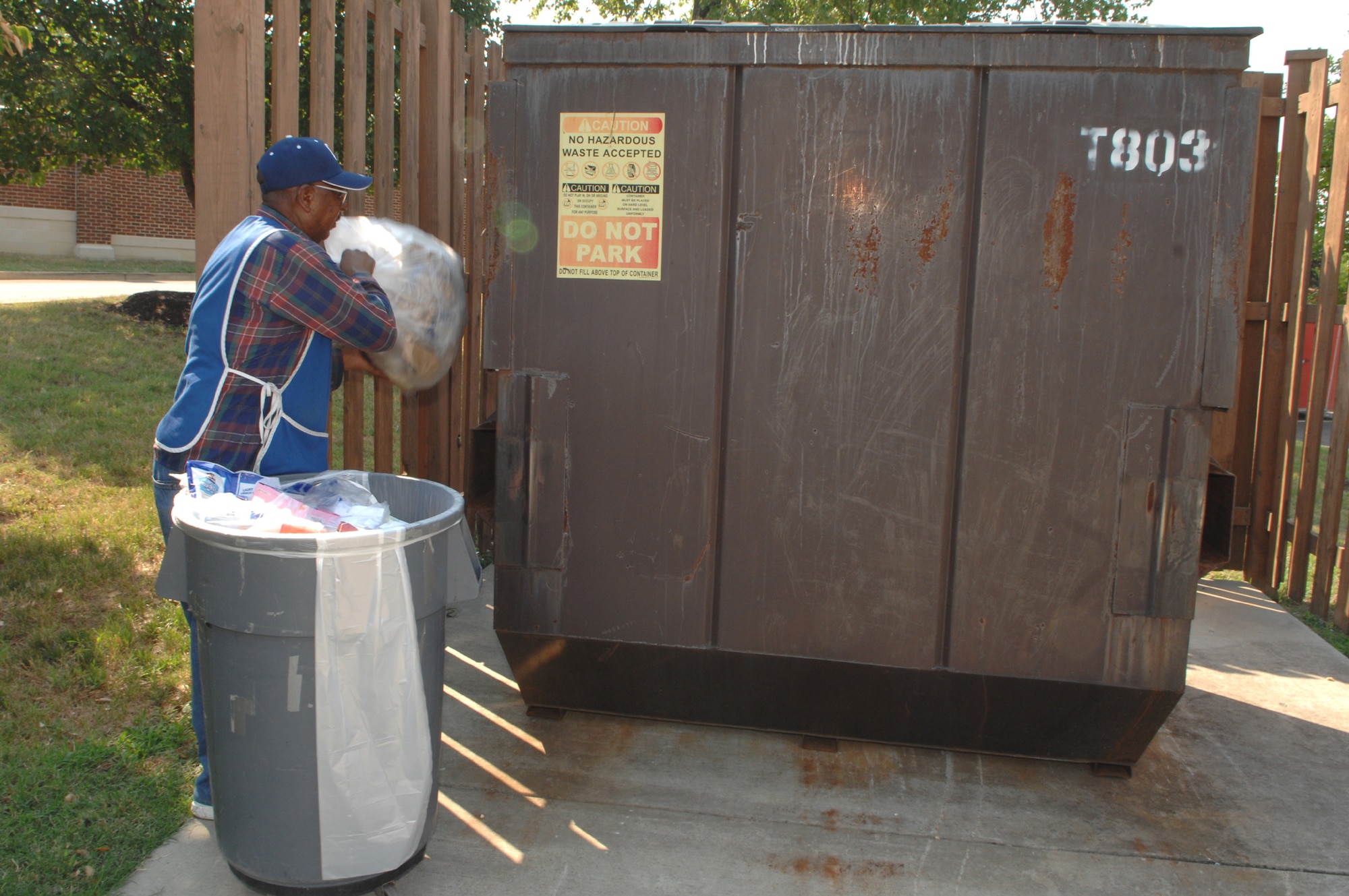 Leroy Carey empties the trash outside the U.S. Air Force Honor Guard building on Bolling Aug. 2. Mr. Carey works for the Goodwill company, which cleans the inside of all offices on base. (U.S. Air Force photo by Airman 1st Class Timothy Chacon)
