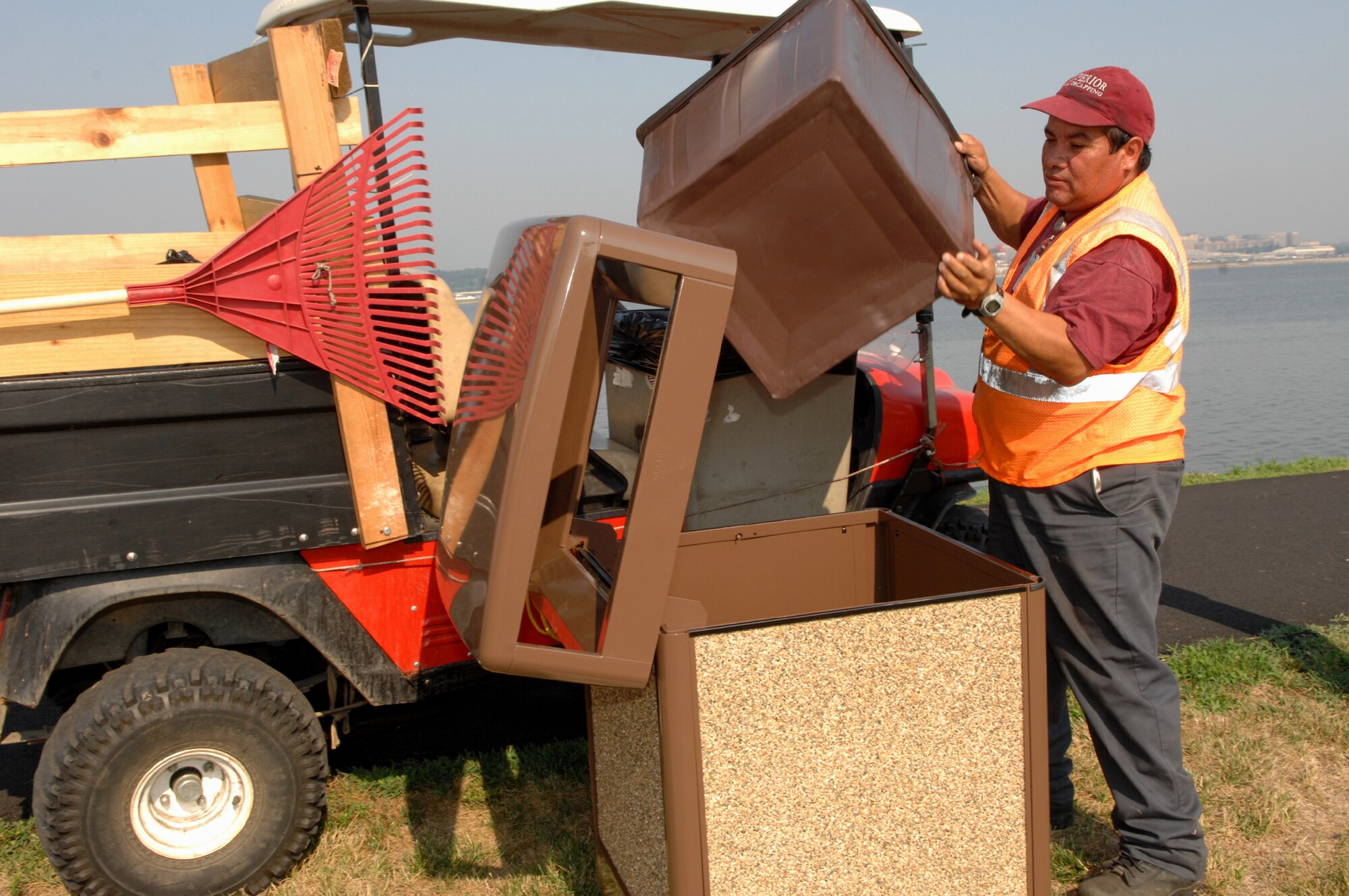 Julio Martinez empties the trash along the Potomac River on Bolling Aug 2. Mr. Martinez is one of the many civilian contractors that take care of the grounds on the base, doing any number of jobs that keep our base well maintained and looking good. (U.S. Air Force photo by Airman 1st Class Timothy Chacon)