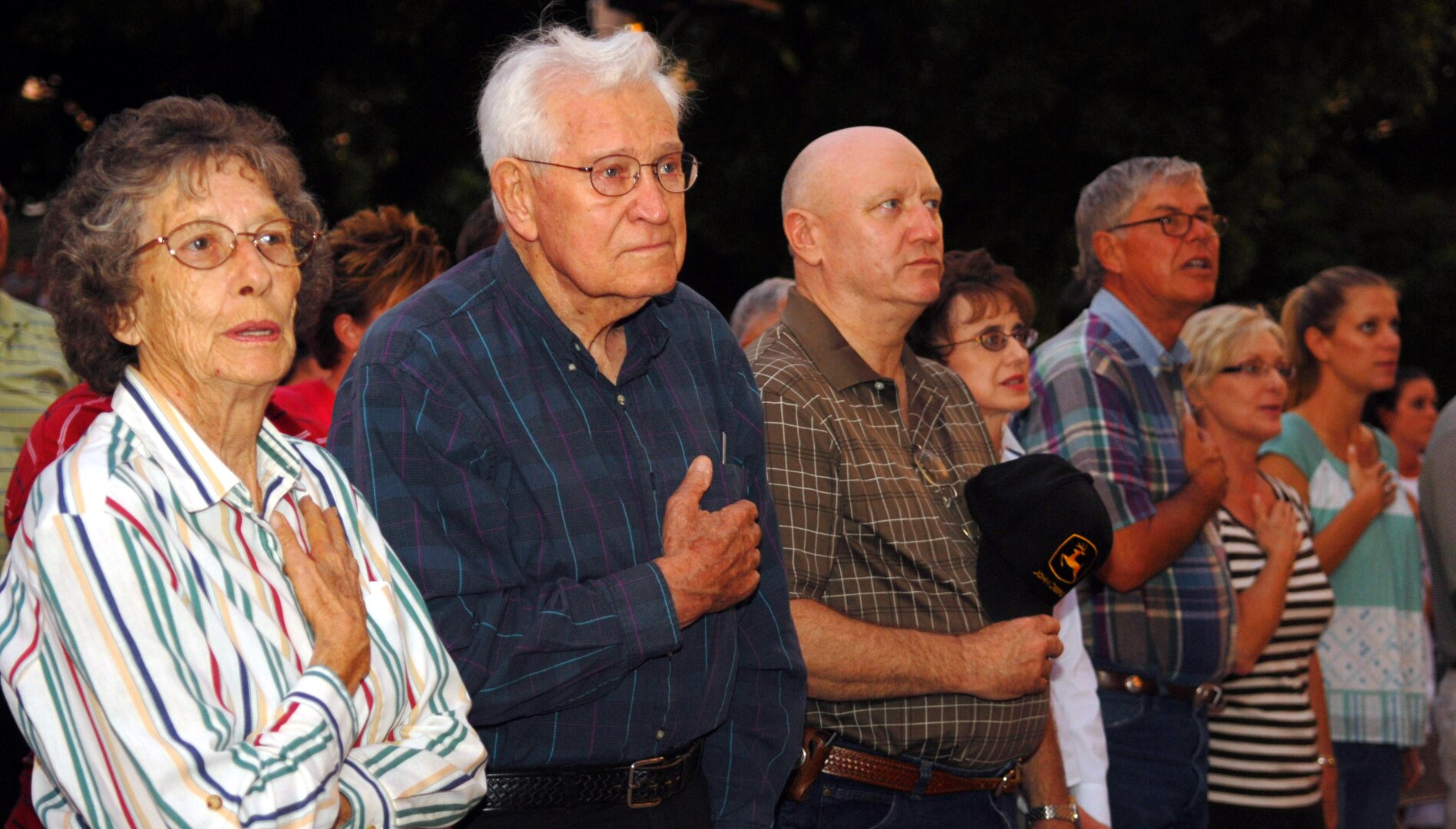 Spectators look on with hands over their hearts as the San Angelo Symphony Orchestra plays the national anthem during the Pops Concert July 3. Active duty and retired members of all services stood during the playing of their respective services’ songs. (U.S. Air Force photo by Airman 1st Class Kamaile Chan)
