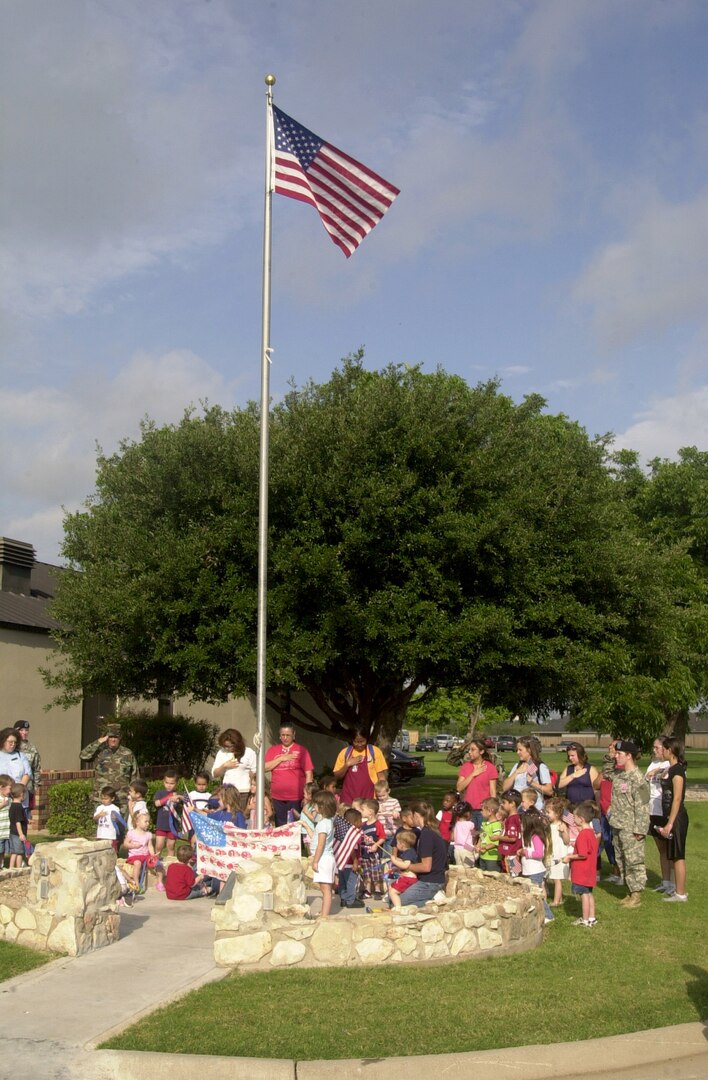 Children, parents and staff from the Child Development Center recite the pledge of allegiance July 3 at the flag pole in front of the Goodfellow NCO Academy. (U.S. Air Force photo by Airman 1st Class Stephen Musal)